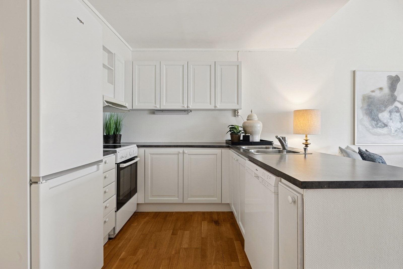 Kjøkkenet er svært bruksvennlig. Innredning fra byggeåret med speilfronter og laminat benkeplate. Galleribilde