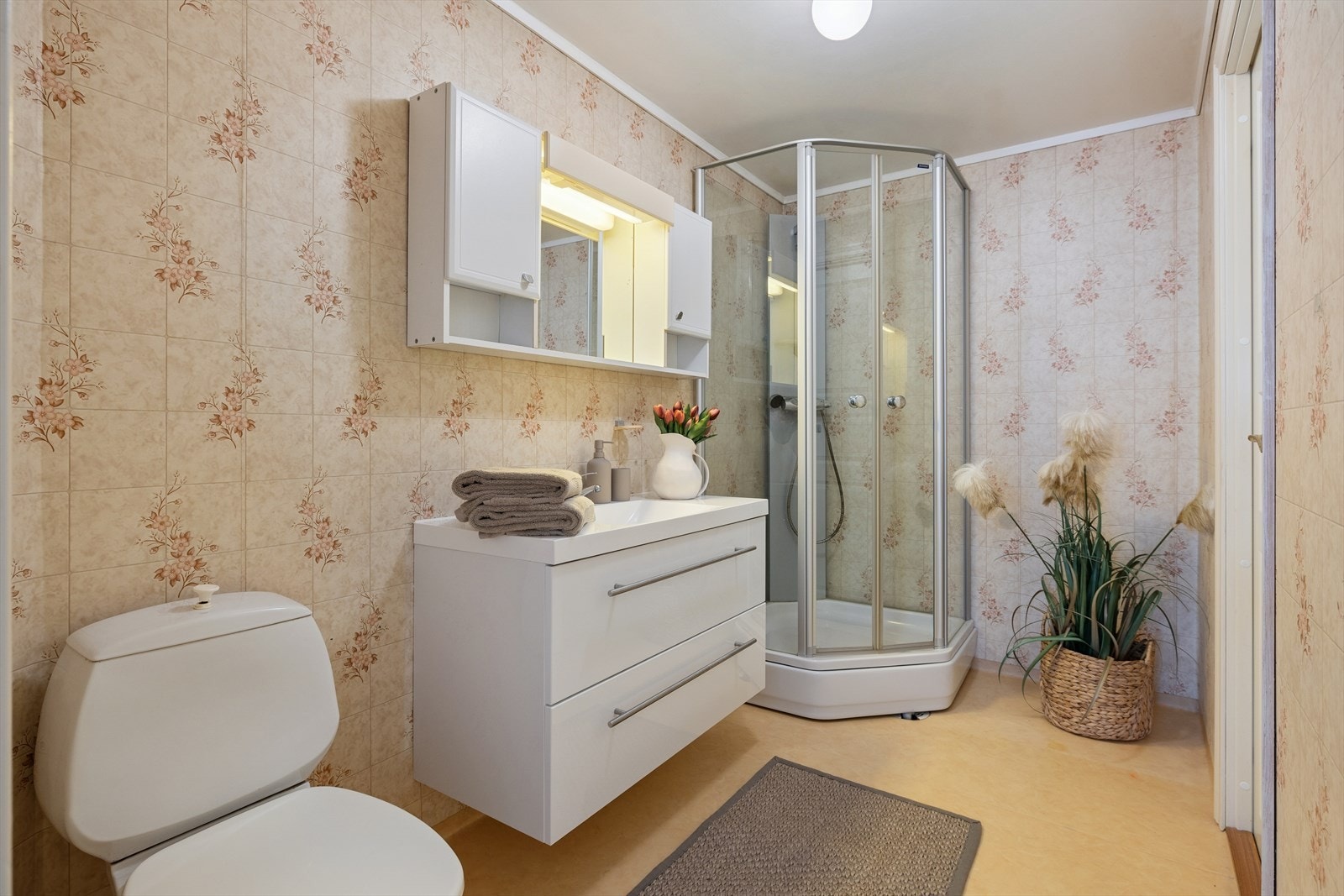 Badet i 3. etasje har belegg på gulvet og plater på veggene. Servantinnredning m/skuffer, overskap, speil m/belysning, dusjkabinett og toalett. Galleribilde