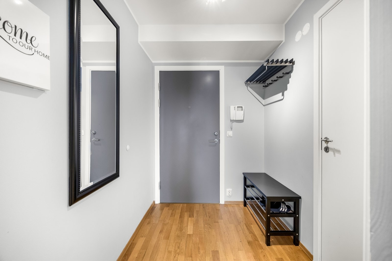 Entreen har lyse overflater, parkettgulv og callinganlegg ved ytterdøren. Plass til knaggrekke og skoskap. Galleribilde