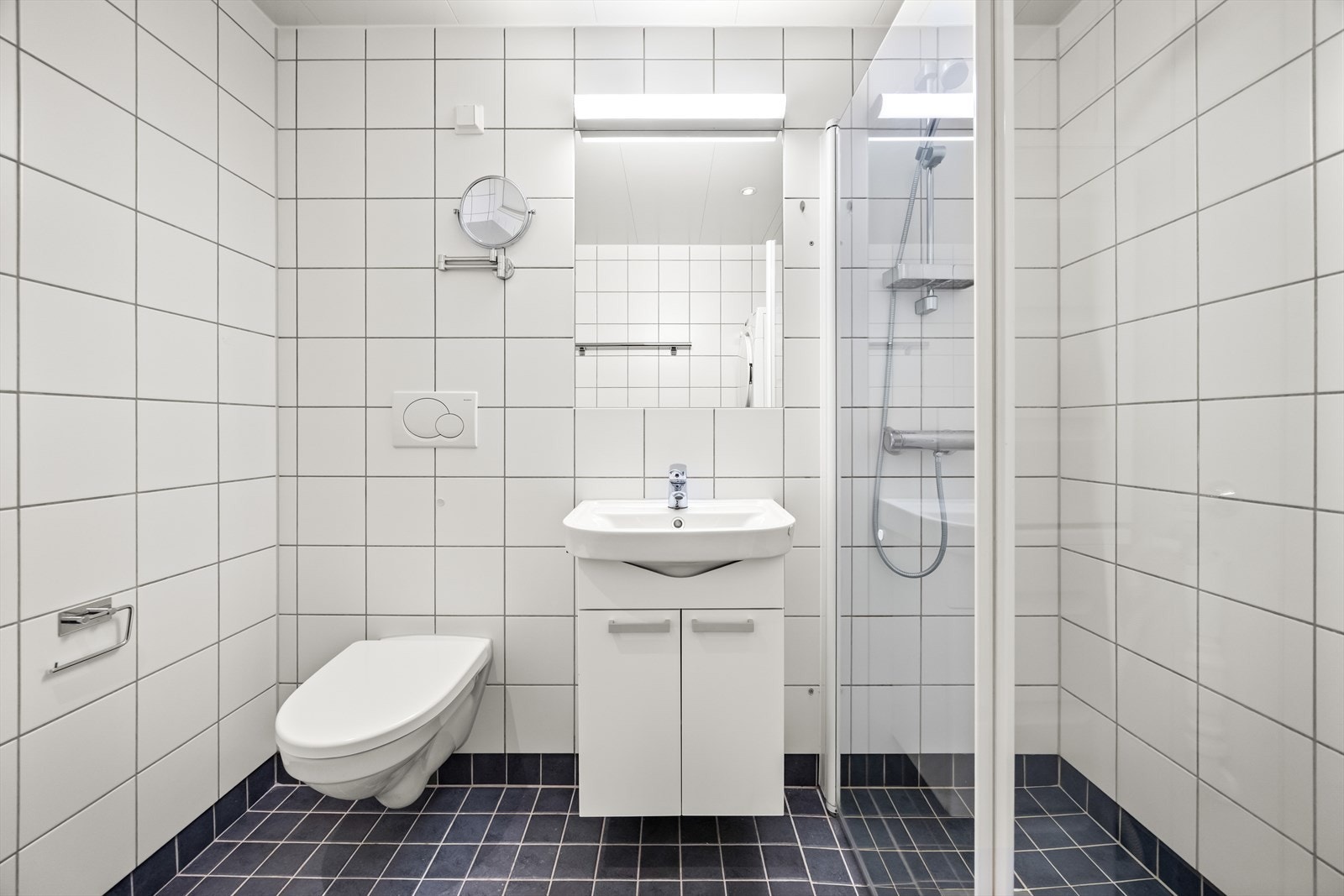 Badet har flislagt gulv med sokkelflis og underliggende varme samt lyse veggfliser. Galleribilde