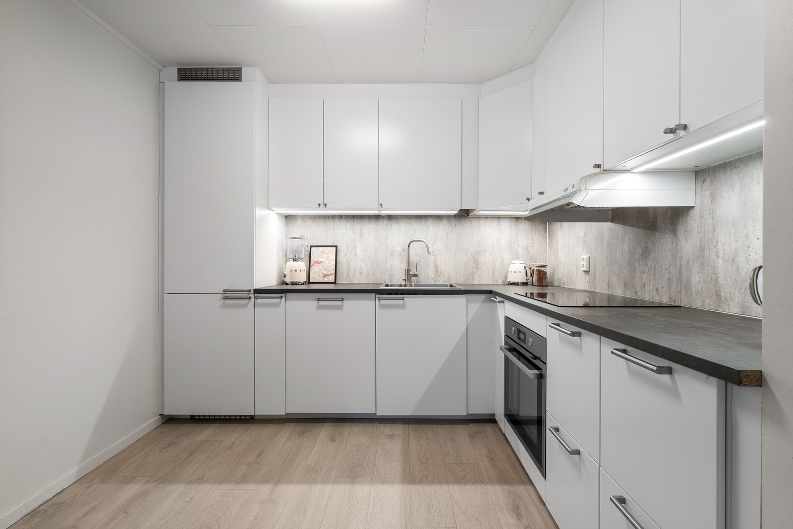 Nytt kjøkken fra 2019 med lyse, slette fronter og takhøye overskap Galleribilde