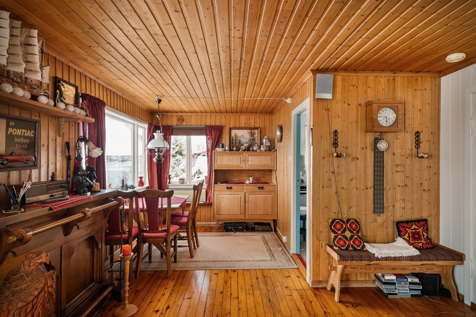 Stuen har et preg av en eldre og tradisjonell hyttestil med heltre panel og lakkete tregulv. Galleribilde