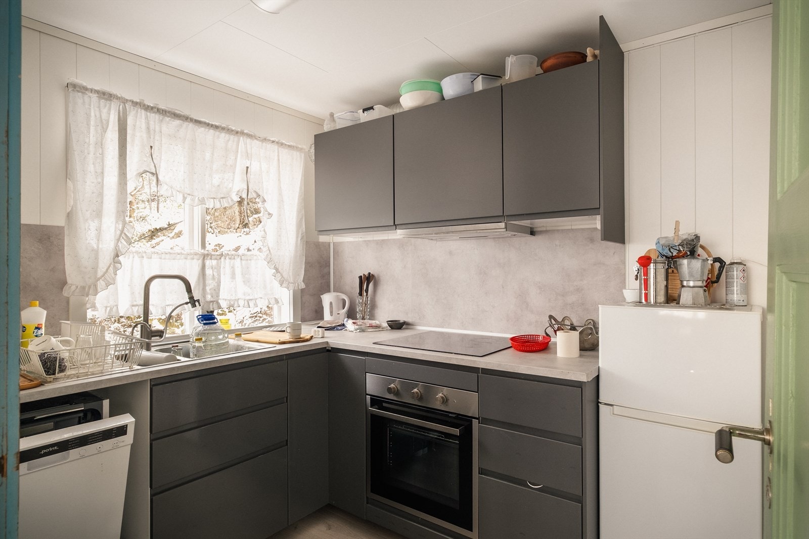 Kjøkkenet er innredet med glatte fronter, benkeplate av laminat, integrert stekeovn, platetopp og oppvaskmaskin. Galleribilde