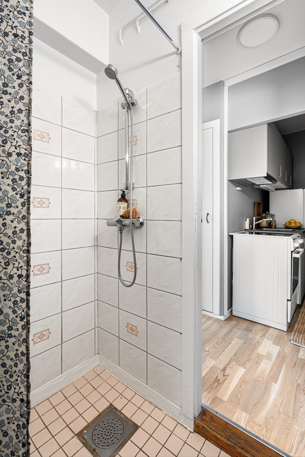 Badet har fliser på gulv samt i vegg i dusjen. Galleribilde