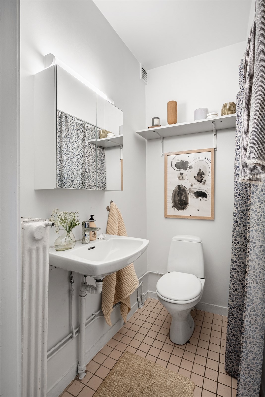 Bad med frittstående toalett, innredning med servant m/1-greps blandebatteri og åpen dusjplass med blandebatteri. Galleribilde