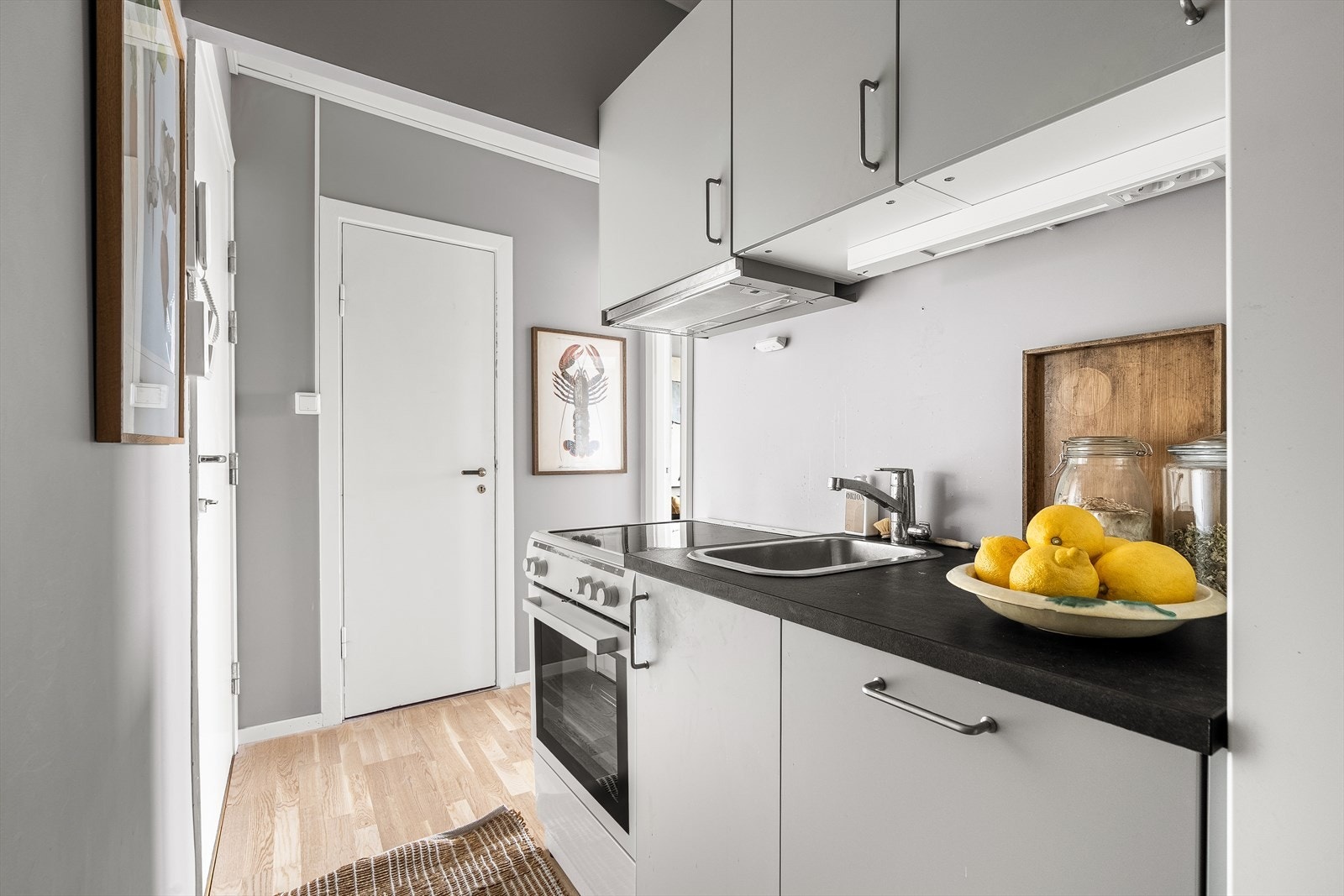 Praktisk hybelkjøkken med malte fronter. Avtrekksvifte med kullfilter over komfyr. Galleribilde