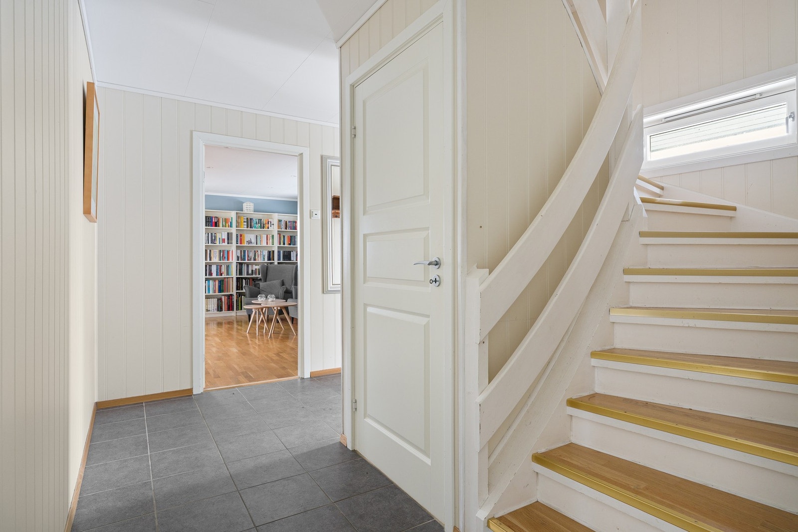 Boligen har en romslig og entré med fliser på gulv, som er både praktisk og stilrent. Rommet er lyst og innbydende, med plass til garderobeløsning i form av skap, kommode eller lignende. Galleribilde
