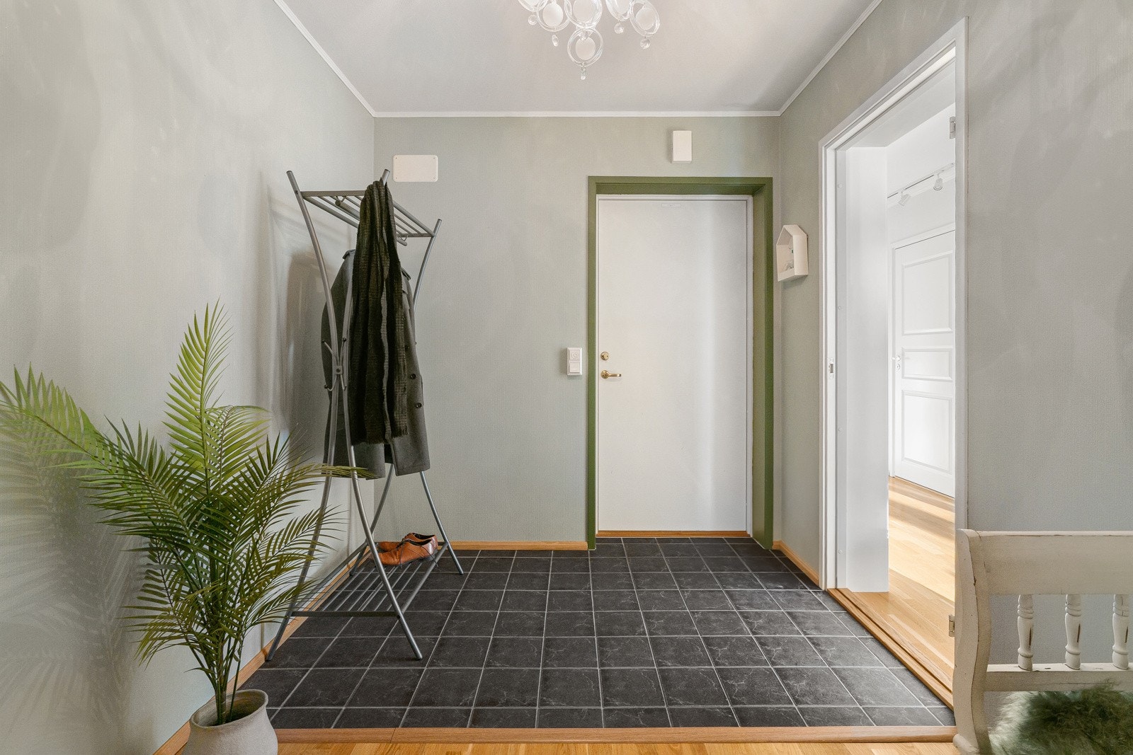 Flislagt entrè med plass for å etablere lekre plassbygde løsninger for sko og yttertøy.
