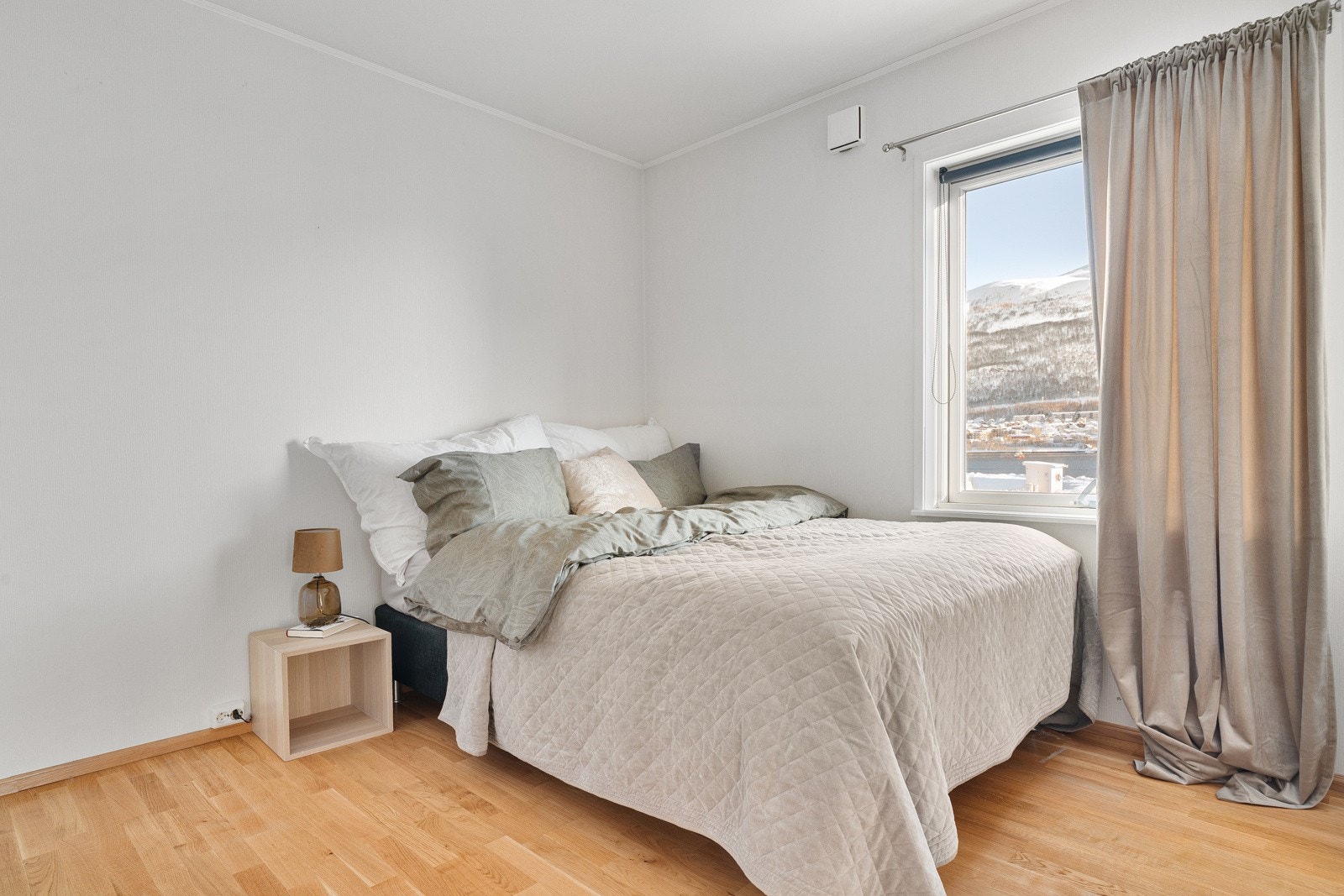 Boligens hovedsoverom er av god størrelse med plass for stor seng og tilhørende nattbord.