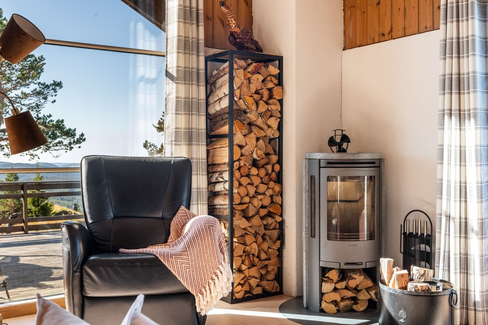 I det ene hjørnet av stuen er det installert vedovn med glassdør som gir fint innsyn til flammene. Galleribilde