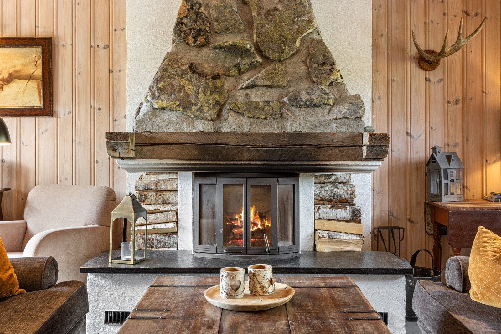 Gedigen peis midt i stuen bygget med naturstein plukket i nærområdet Galleribilde