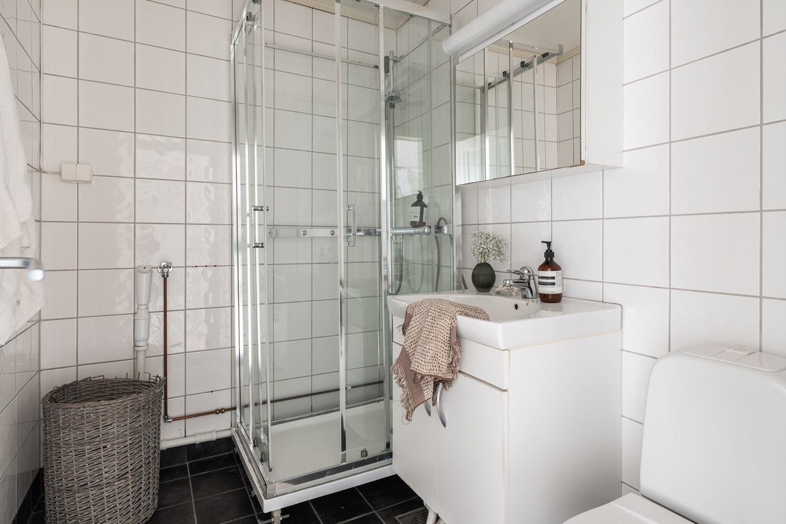 Funksjonelt bad med flislagte overflater og opplegg for vaskemaskin. Galleribilde