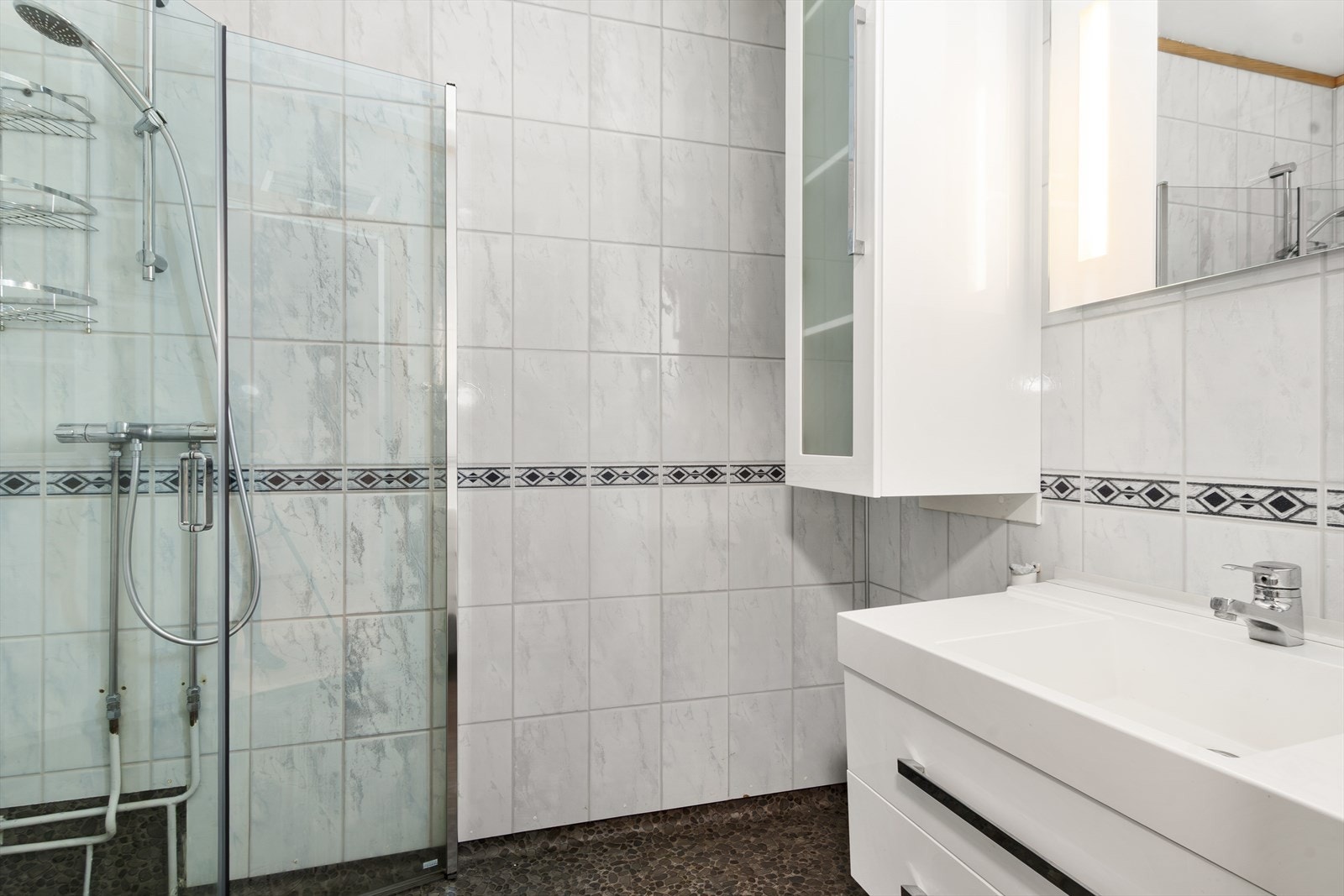 Badet har vinylbelegg på gulvet, våtromsplater på veggene og slett malt tak. Galleribilde