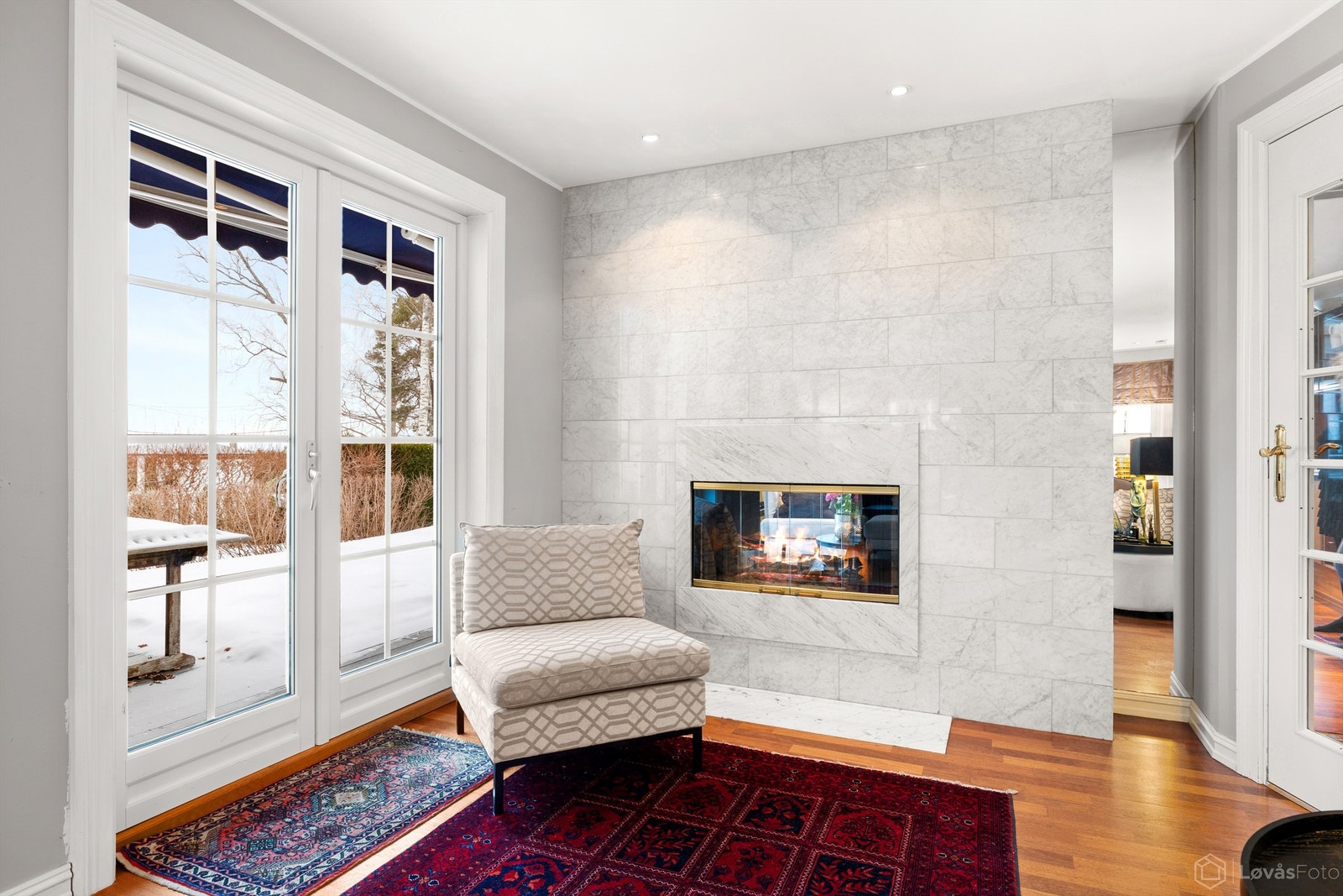 Gjennomgående peis mellom stue og kjøkken med glassdører, for ekstra hygge og varme Galleribilde