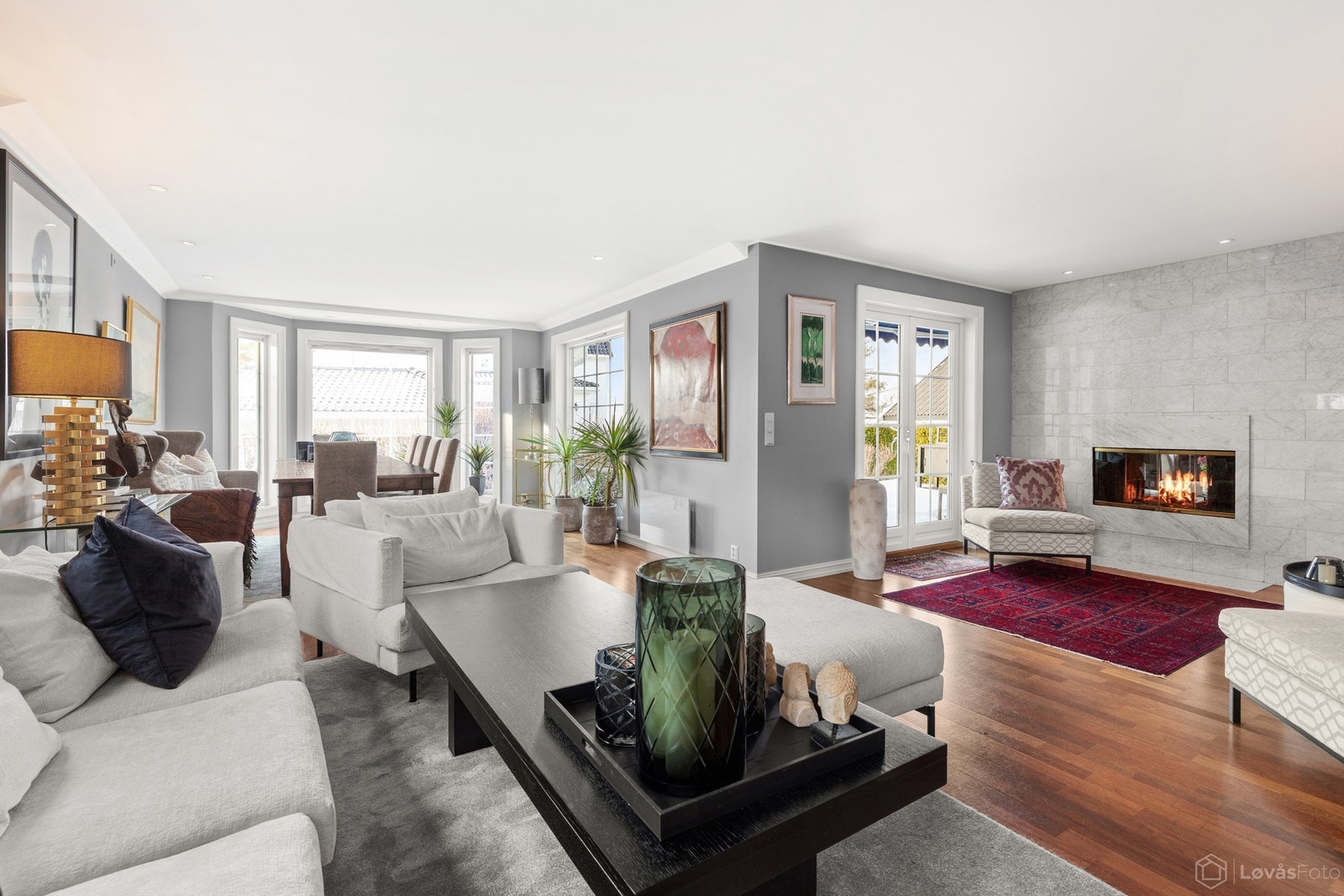 Stor kombinert stue og spisestue med store vindusflater som gir rommet rikelig med lys Galleribilde