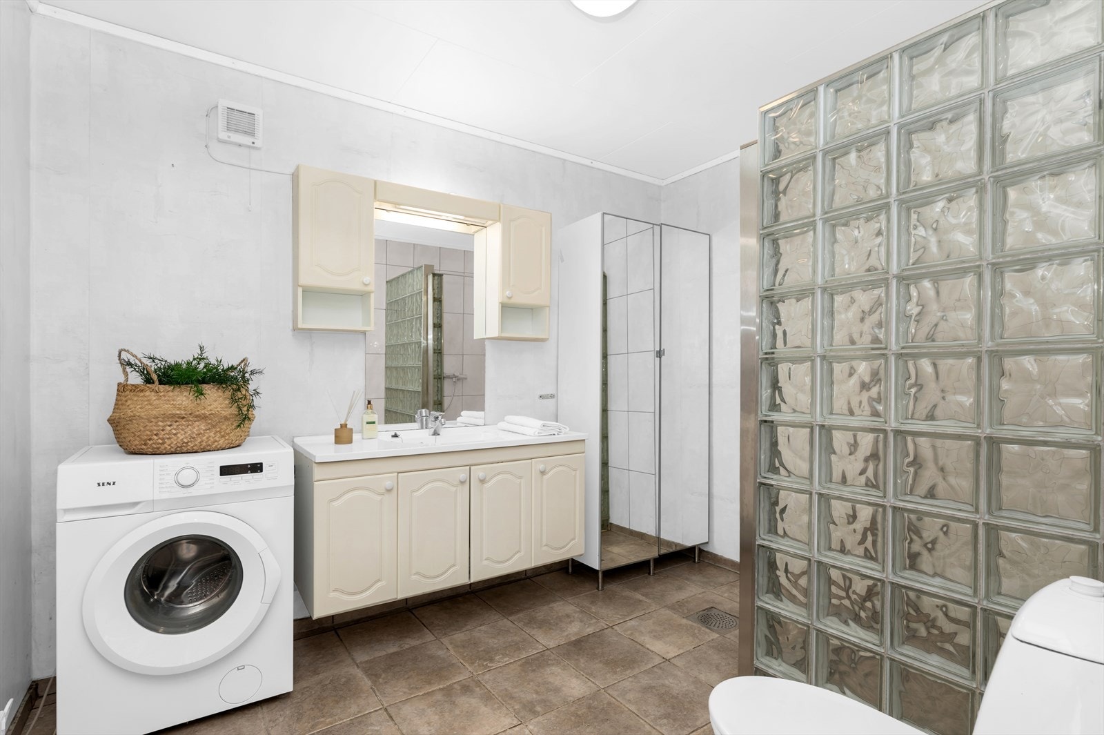 Romslig bad med fliser og varmekabler i gulv. Opplegg til vaskemaskin Galleribilde