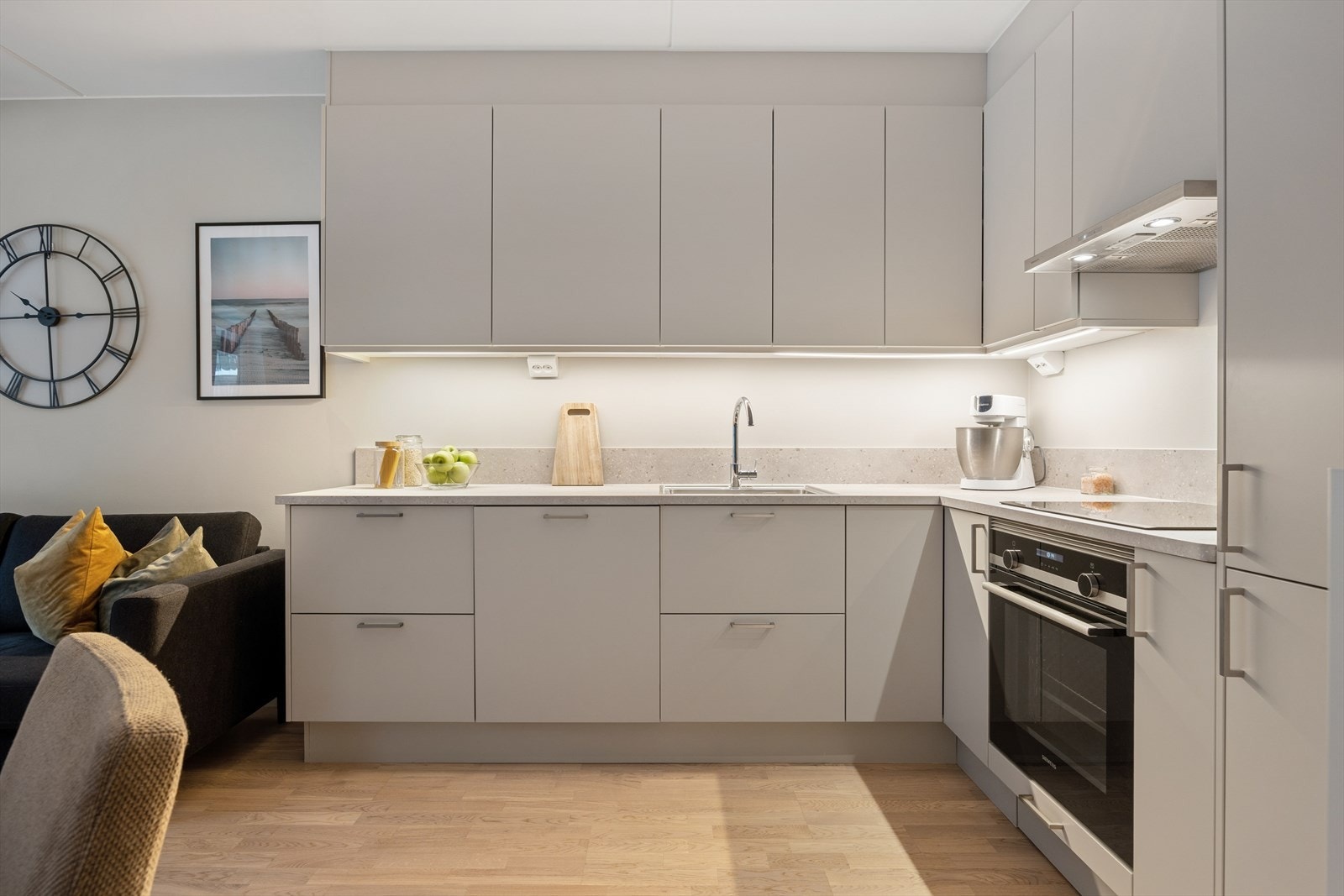 Kjøkkeninnredning med glatte fronter og laminat benkeplate. Integrert platetopp, stekeovn samt kjøle- og fryseskap. Galleribilde