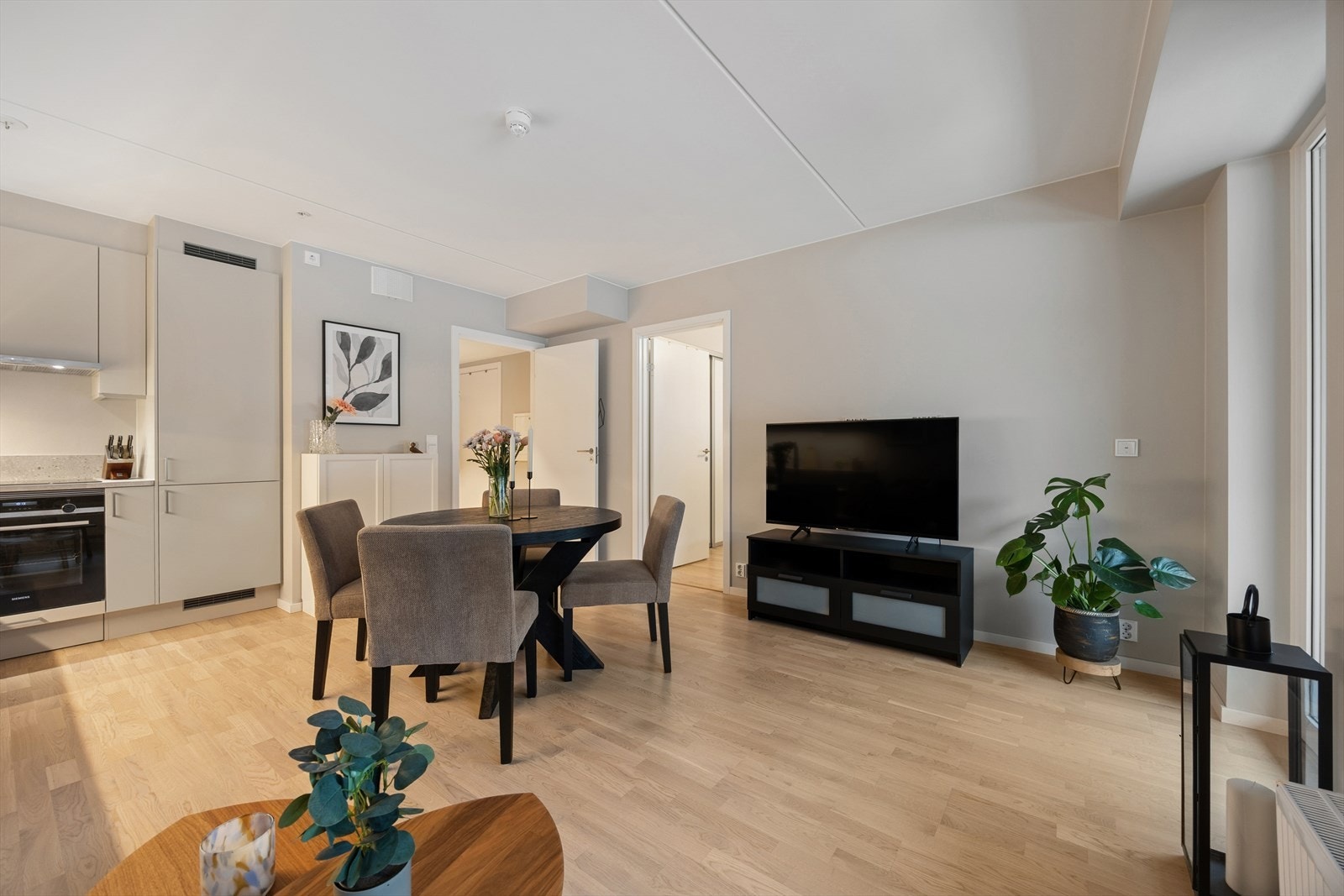 God takhøyde og store vindusflater ut mot balkong gir stuen en luftig romfølelse. Galleribilde