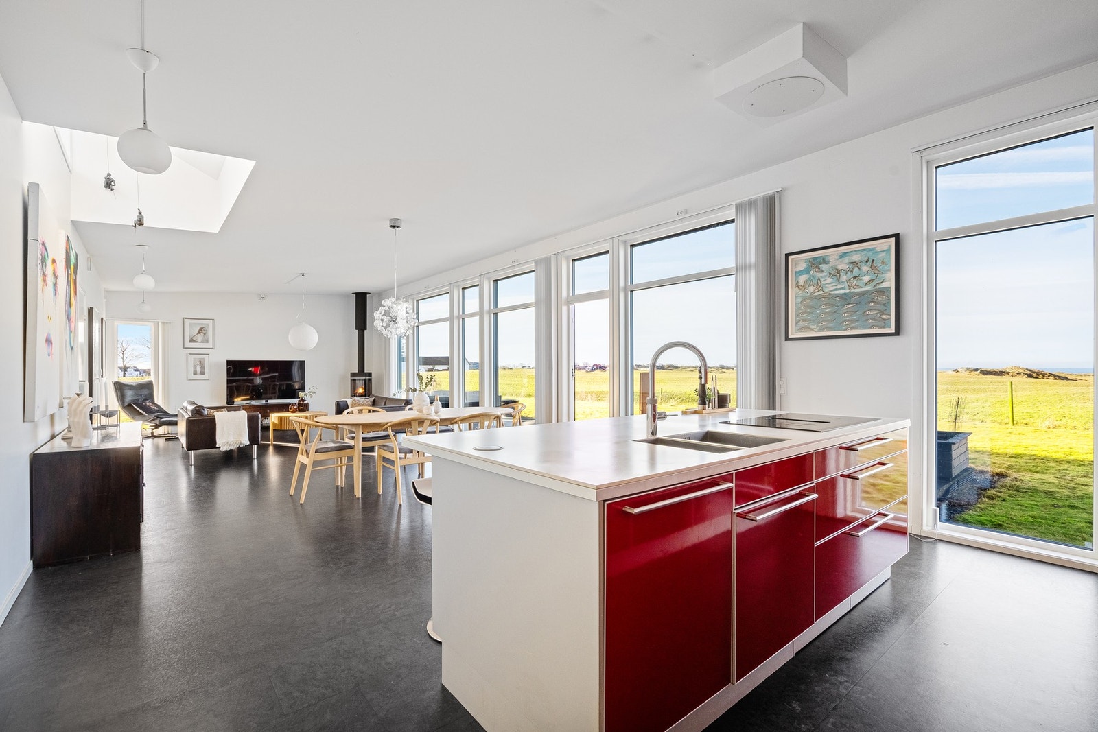 Kjøkken og stue i sømløs, sosial løsning med naturlig samspill mellom sonene. Galleribilde