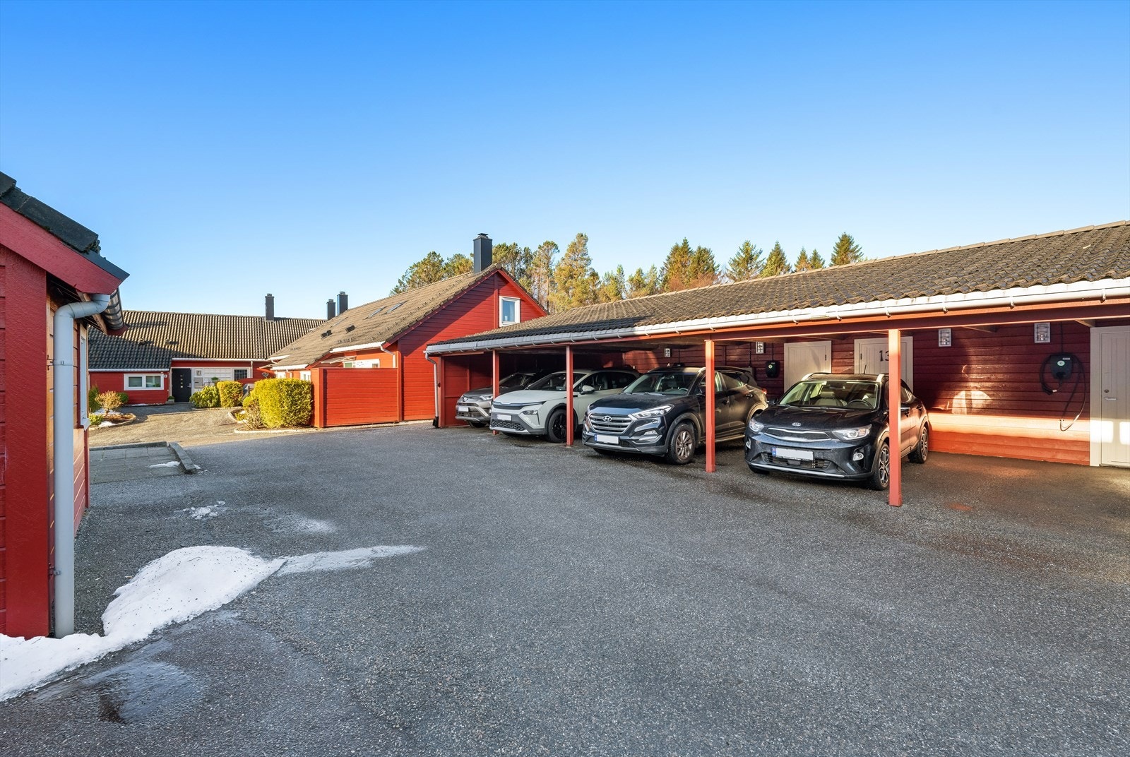 Oppstillingsplasser under carport. Det er bod i bakkant av parkeringsplass Galleribilde