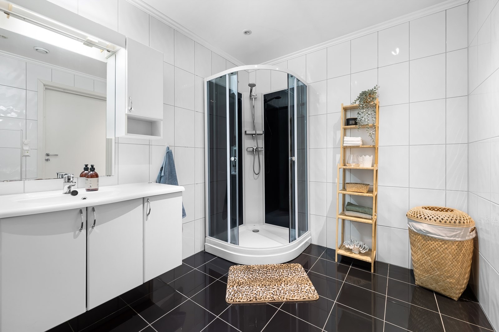 Badet er helfliset og pent innredet med toalett, dusjkabinett og skapinnredning med servant. Galleribilde