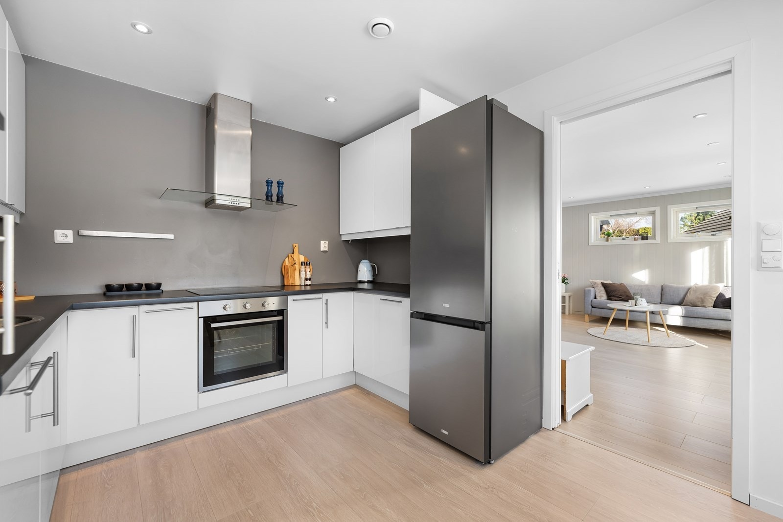 Kjøkkenet har lekker innredning med hvite glatte fronter og laminert benkeplate. Galleribilde