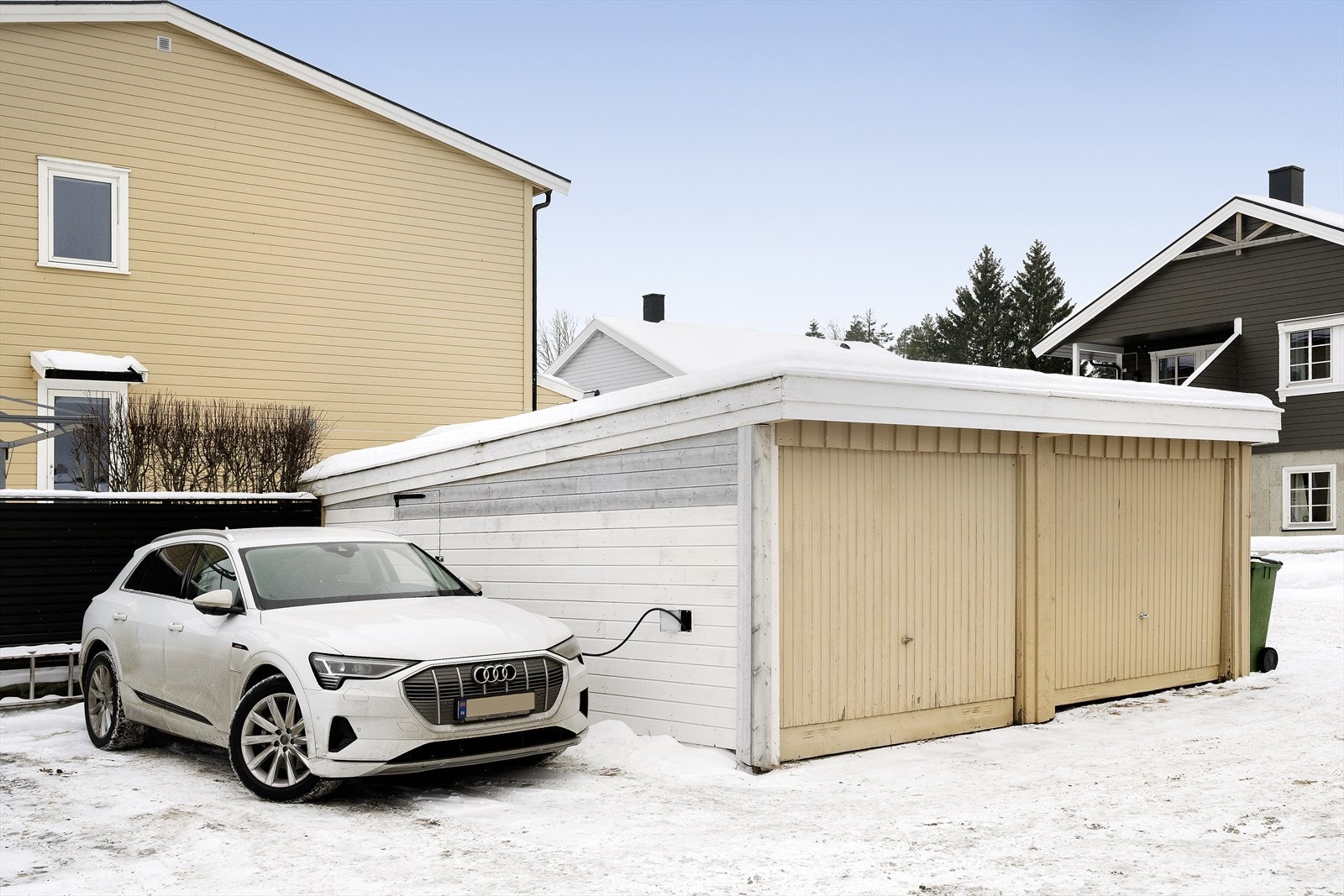 Garasjeplass i rekke utenfor huset. El.bil-lader er montert. P-plass ved siden av garasje Galleribilde