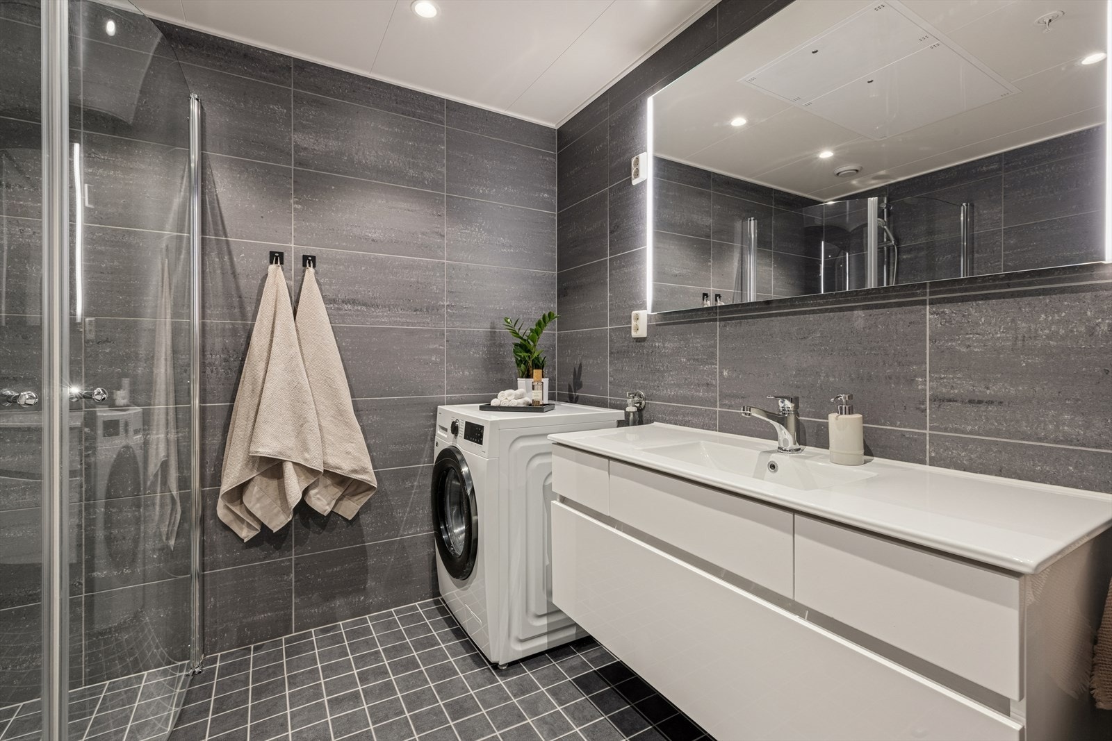 Pent flislagt baderom med behagelig vannbåren varme i gulvet. Rommet har også opplegg for vaskemaskin. Galleribilde