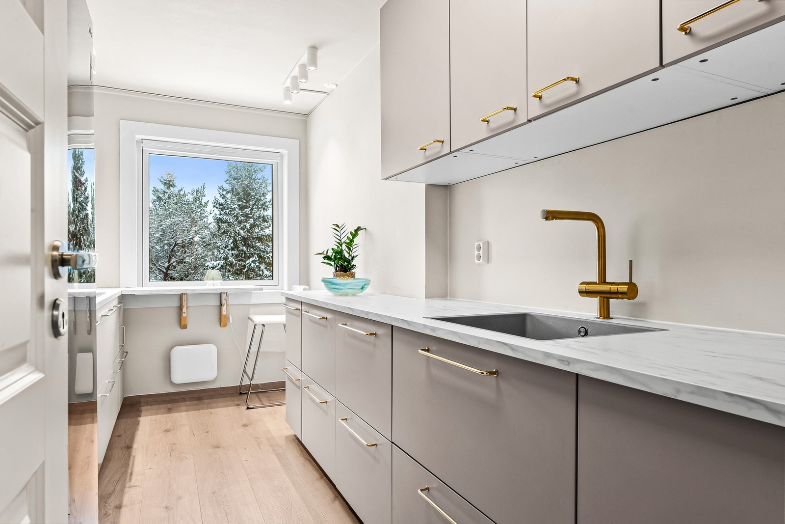 Leiligheten har en ny, pen kjøkkeninnredning fra 2024/25, som består av benke og overskap med slette fronter og dempefunksjoner. Galleribilde