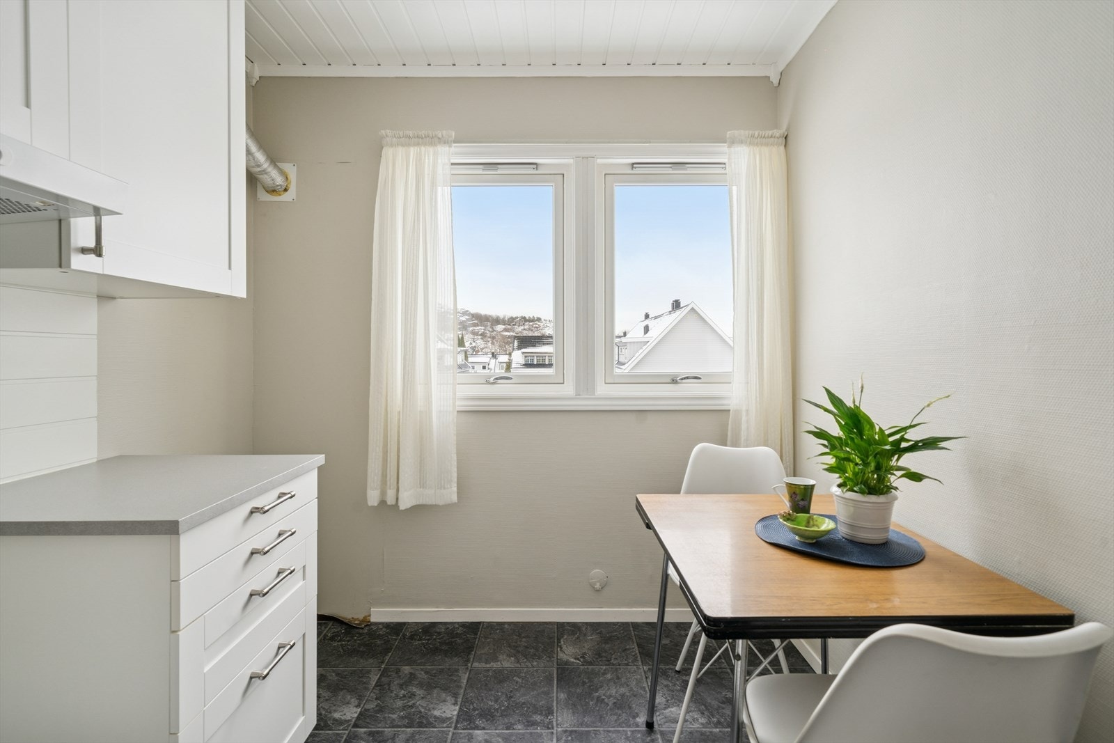 Kjøkkenet har en enkel innredning med hvite, profilerte fronter. Galleribilde