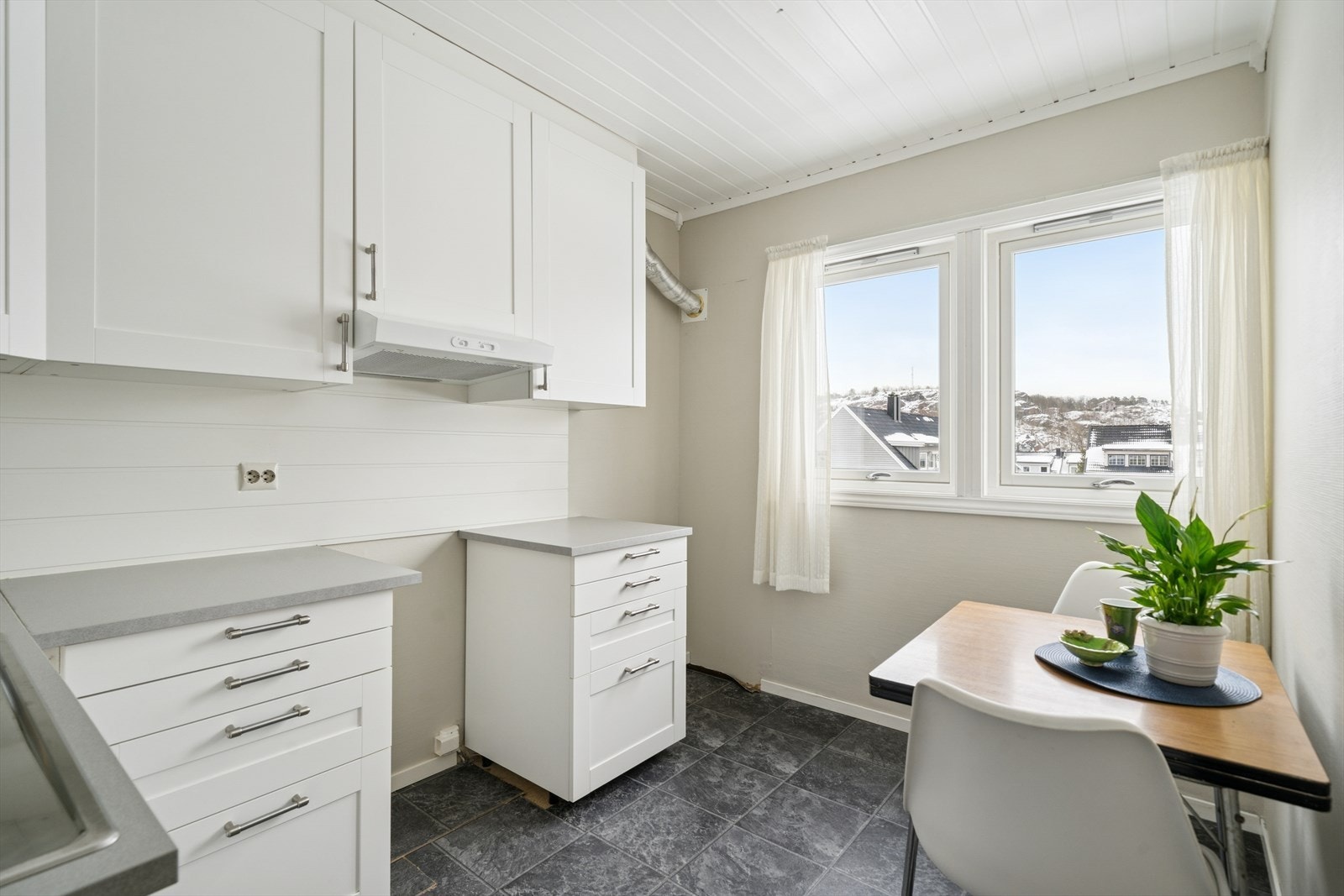 Kjøkkenet ligger i eget rom og har fint utsyn mot nærområdet. Noen beboere har etablert uteplass ved å legge platting, og sette inn verandadør her. Hvis dette er ønskelig for deg også, må du avklare det med styreleder først. Galleribilde