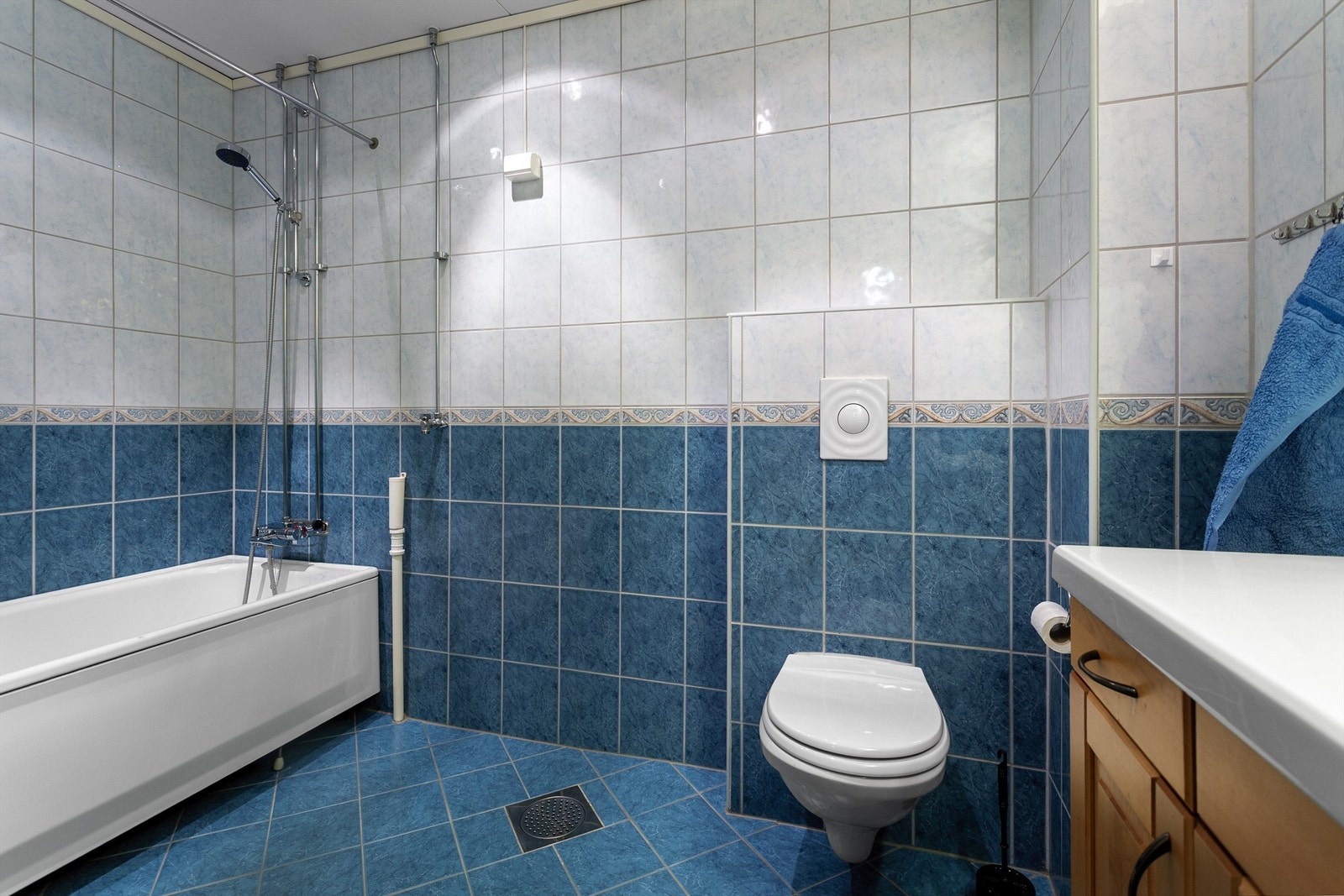 Innredningen består av en servant nedfelt i underskap, vegghengt toalett og badekar. Galleribilde