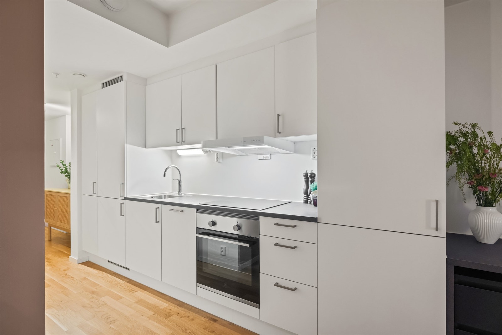 Kjøkkenet har en stilren innredning med glatte fronter og godt med skapplass. Galleribilde