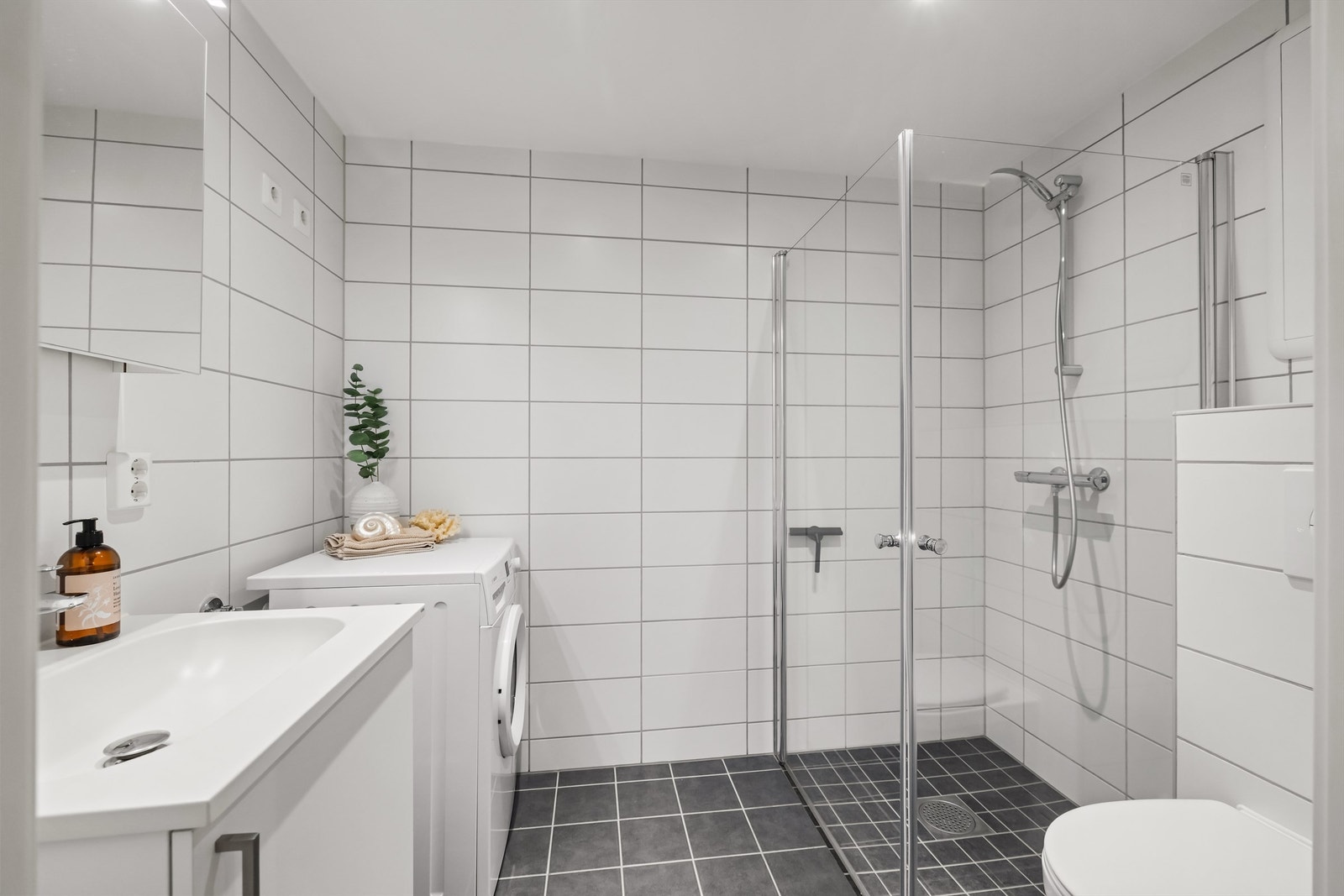 Delikat, flislagt bad med varme i gulvet og opplegg for vaskemaskin. Galleribilde