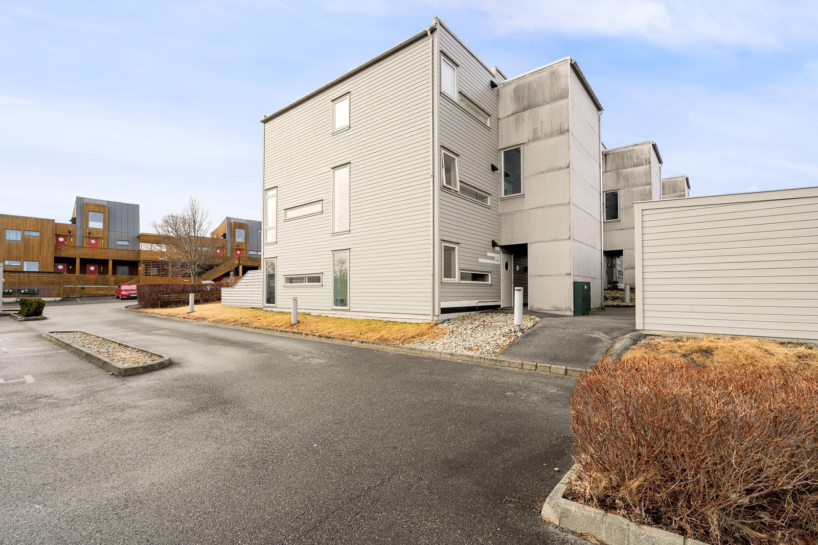 Pent opparbeidet grøntareal med plen, bed og busker. Asfalterte gangveier og lekeplass. Galleribilde