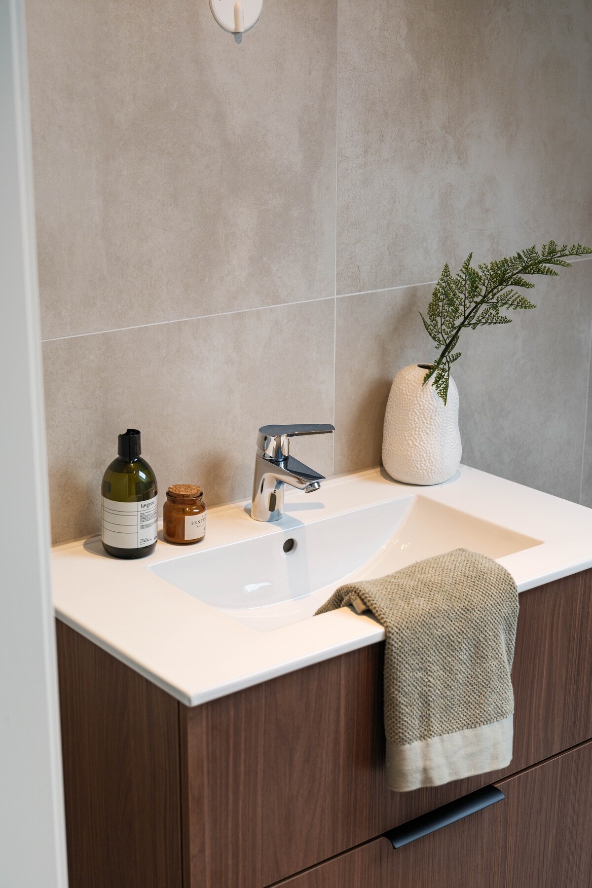 Stilrent servantområde med moderne armatur og elegante fliser. Bildene er fra naboleilighet (15B), med identiske løsninger og materialvalg. Galleribilde