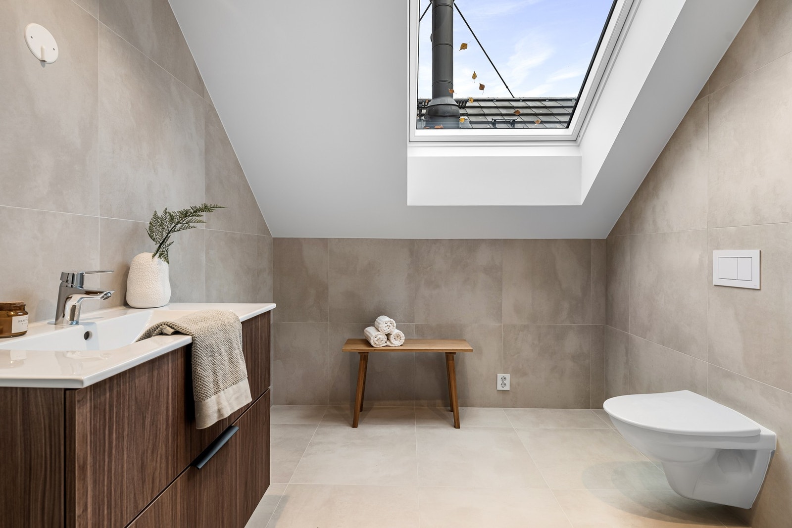 Lekkert bad med takvindu som slipper inn masse lys, moderne innredning og god plass - gir mulighet for spa-følelse og avslapning. Bildene er fra naboleilighet (15B), med identiske løsninger og materialvalg. Galleribilde