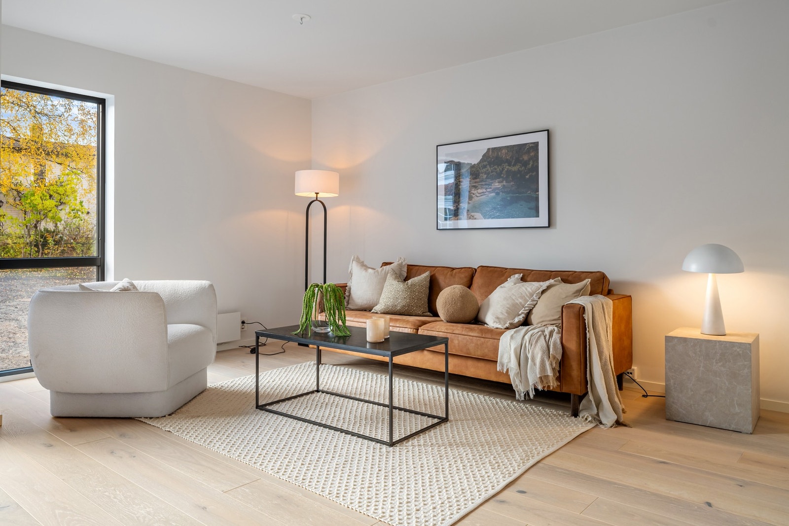 Lun stue med behagelig sofakrok - et perfekt sted å slappe av med en bok eller gode samtaler. Bildene er fra naboleilighet (15B), med identiske løsninger og materialvalg. Galleribilde