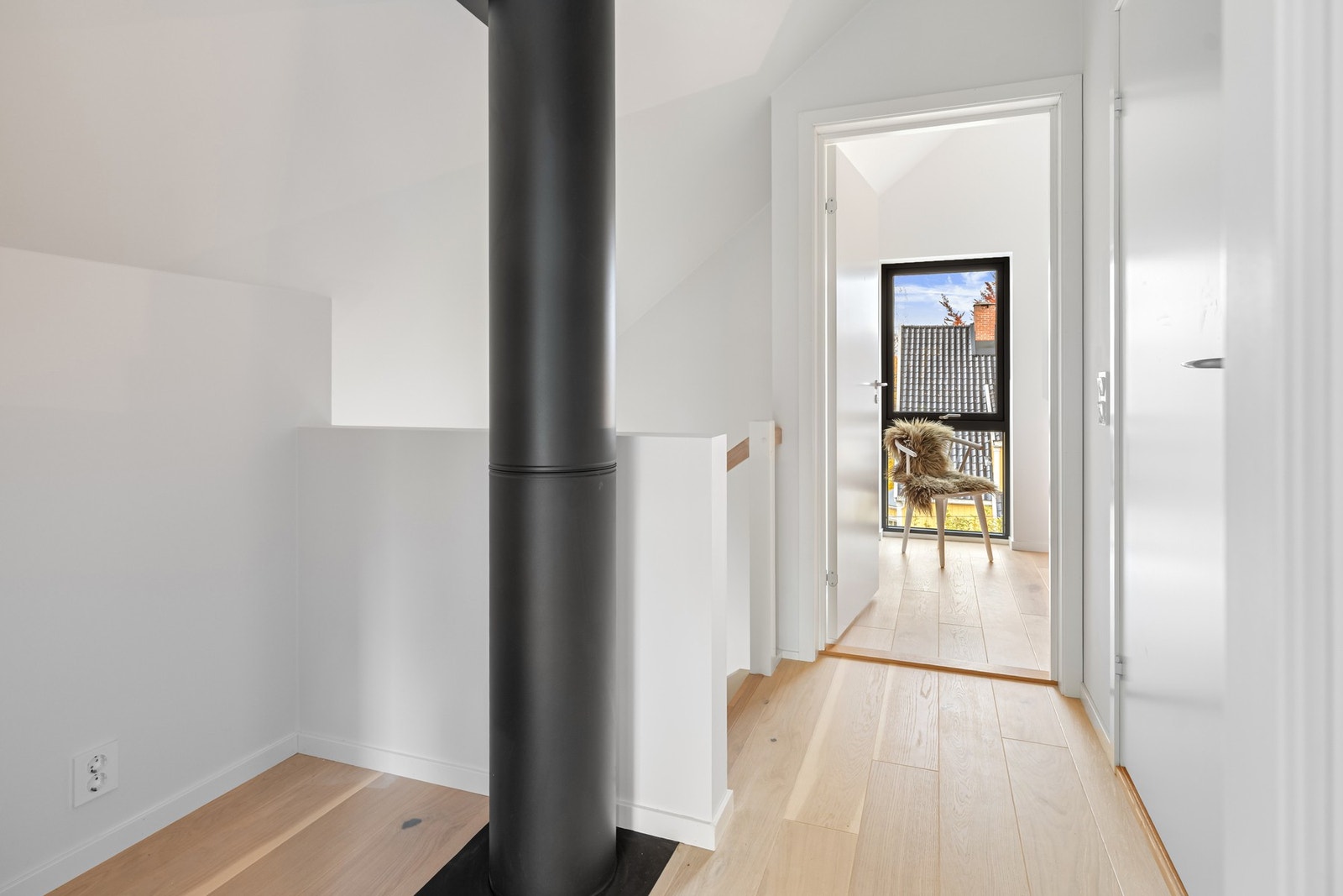 Lyst repos med moderne skorstein gir mulighet for hyggelig kontor- eller leseplass og tilgang til soverom. Bildene er fra naboleilighet (15B), med identiske løsninger og materialvalg. Galleribilde