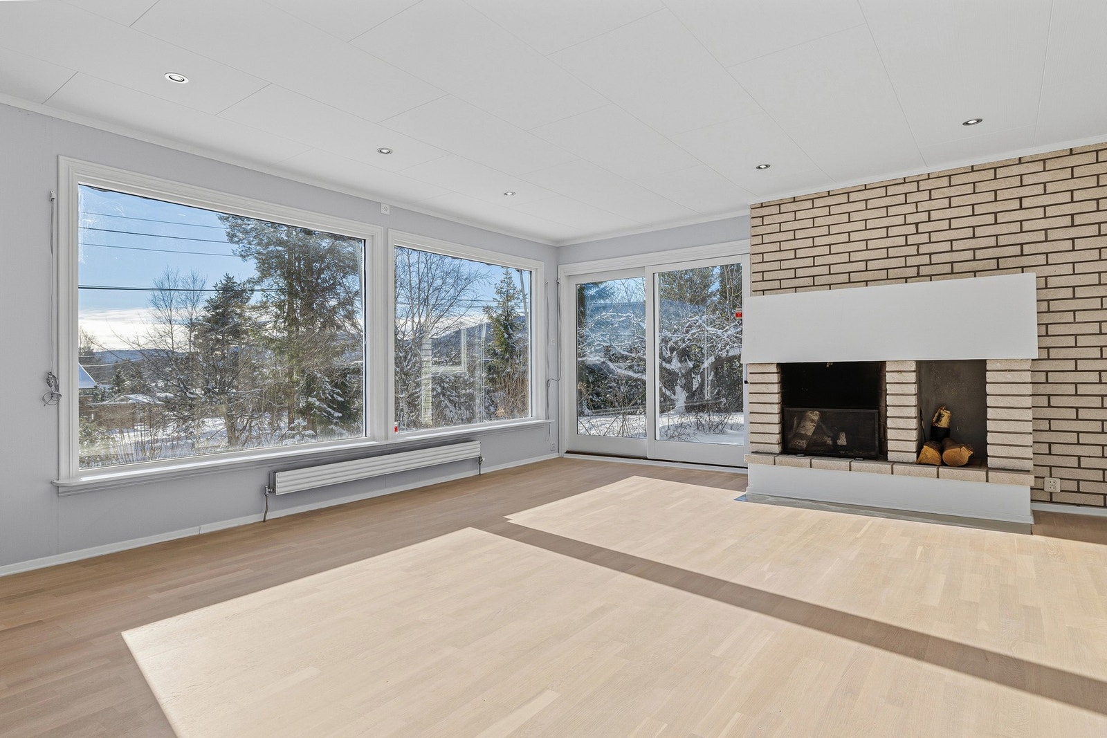 Stuen har en stor peis med åpen grue og rom for lagring av ved Galleribilde