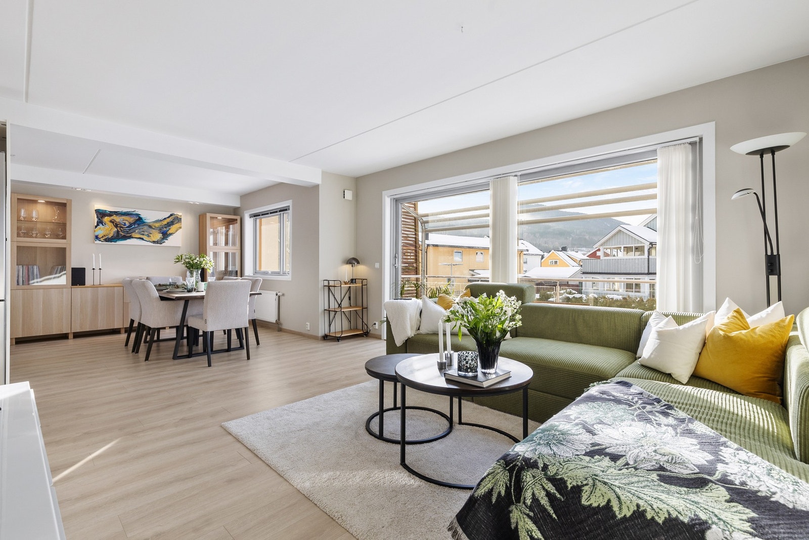 Lys og pen stue med laminatgulv og slette vegger malt i en moderne beige tone Galleribilde