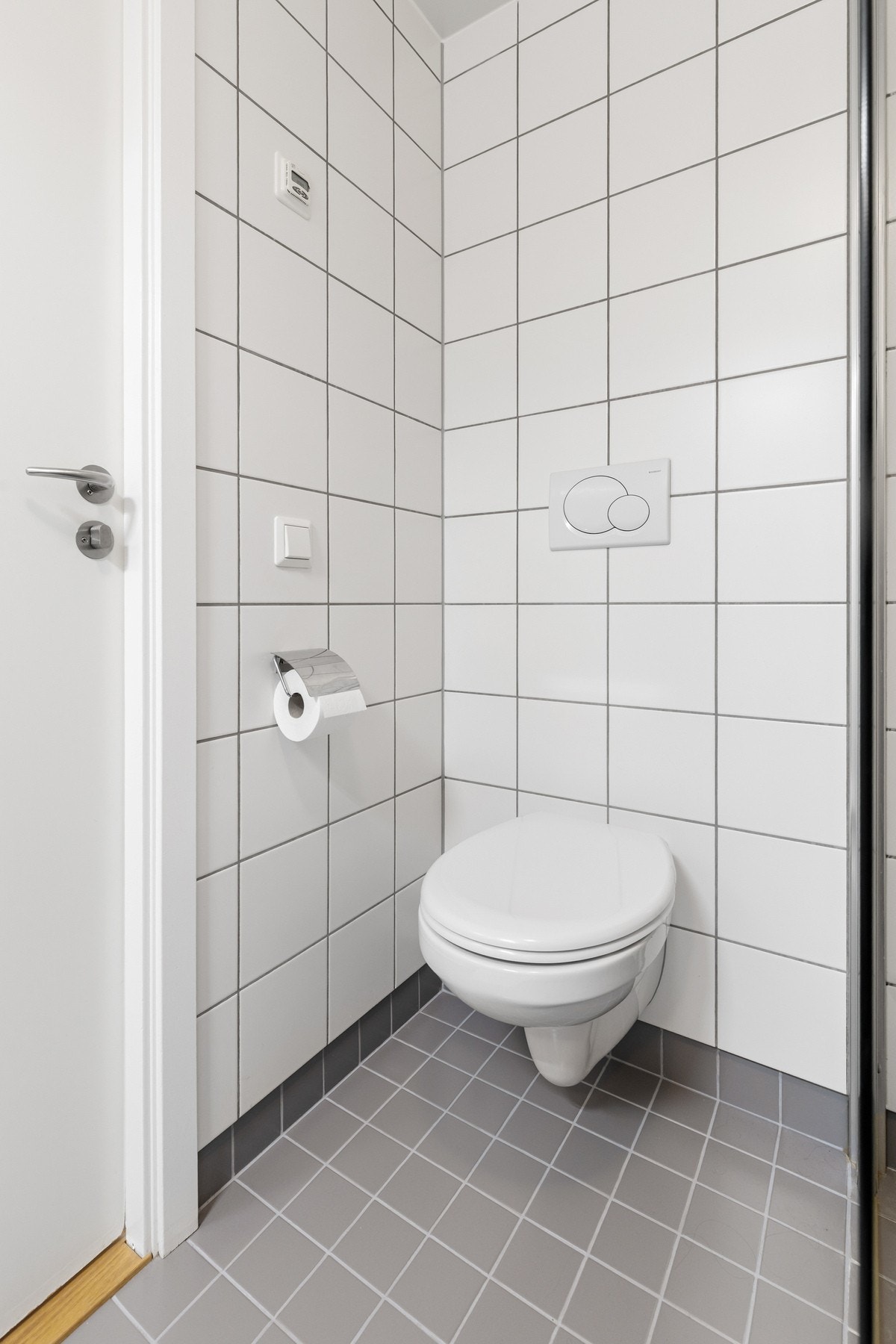 Videre er rommet innredet med vegghengt toalett, nedsenket servant i innredning og dusjnisje med glassdører Galleribilde