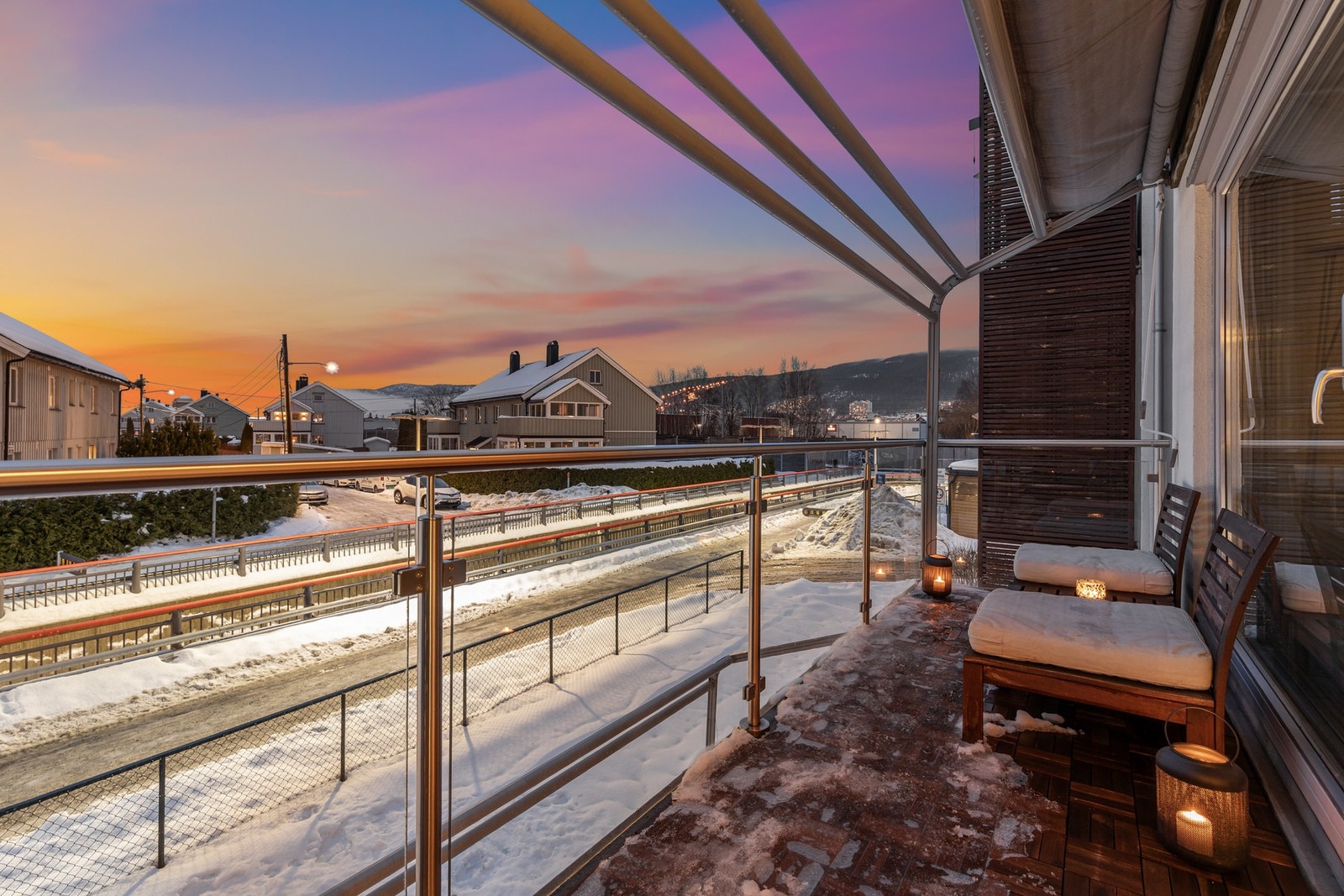 Balkongen har rekkverk i glass og trefliser på gulv Galleribilde