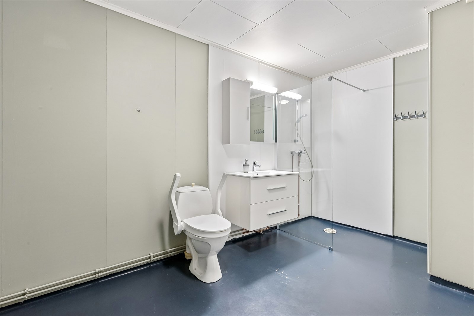 Badet er romslig og praktisk innredet med dusjhjørne, toalett og servant. Galleribilde