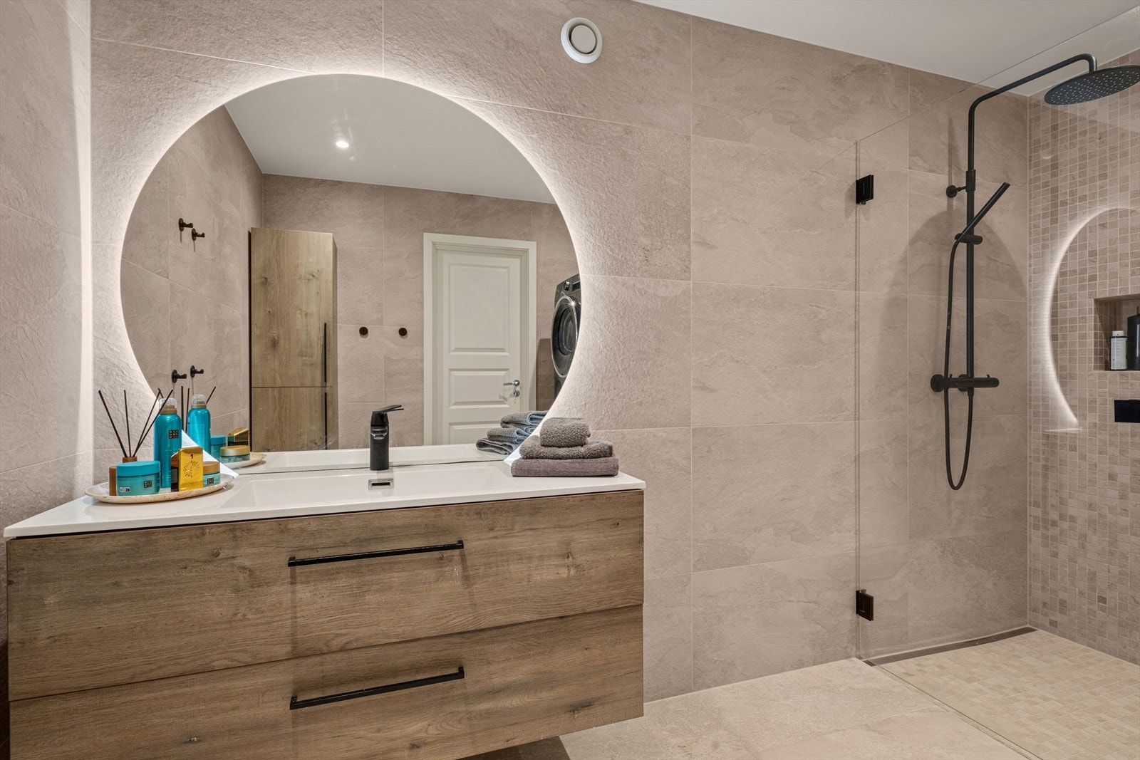 Et lekkert og praktisk innredet bad fra 2024. Delikate fliser, gulvvarme og integrert belysning. Galleribilde