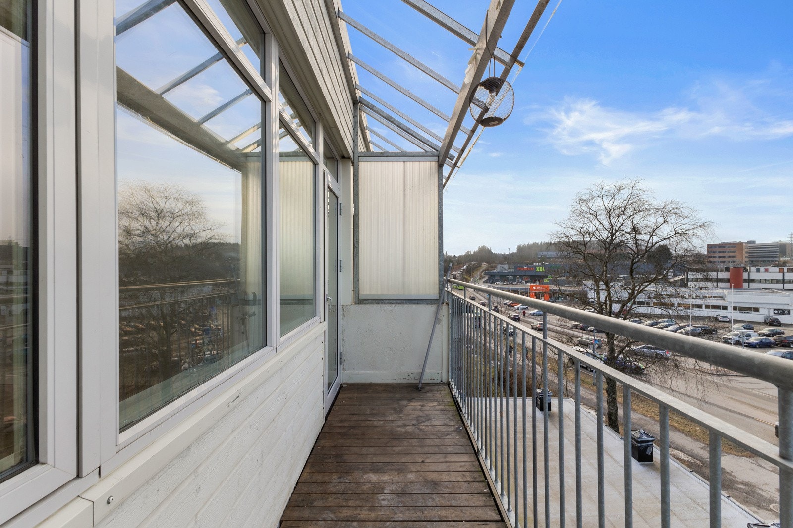 Balkong av betong med tredekke, rekkverk av metall og vegger av mur. Galleribilde