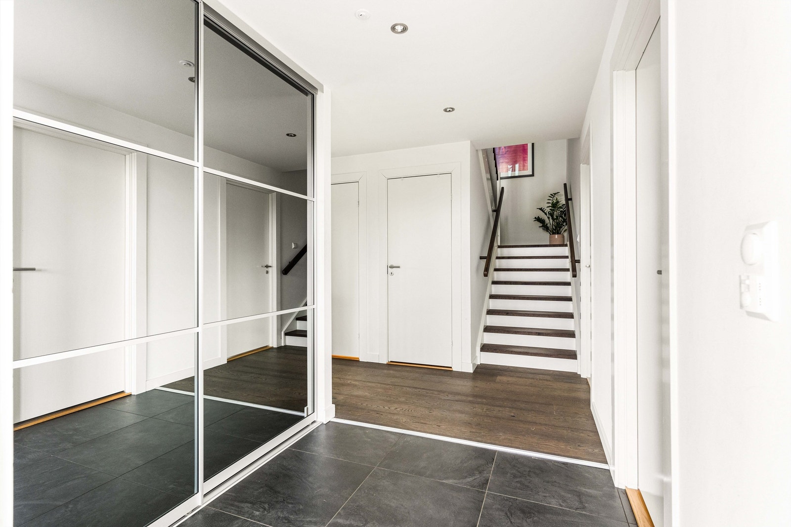 Den romslige entreen gir både funksjonalitet og et stilrent uttrykk med skyvedører som gir enkel oppbevaring av yttertøy. Galleribilde