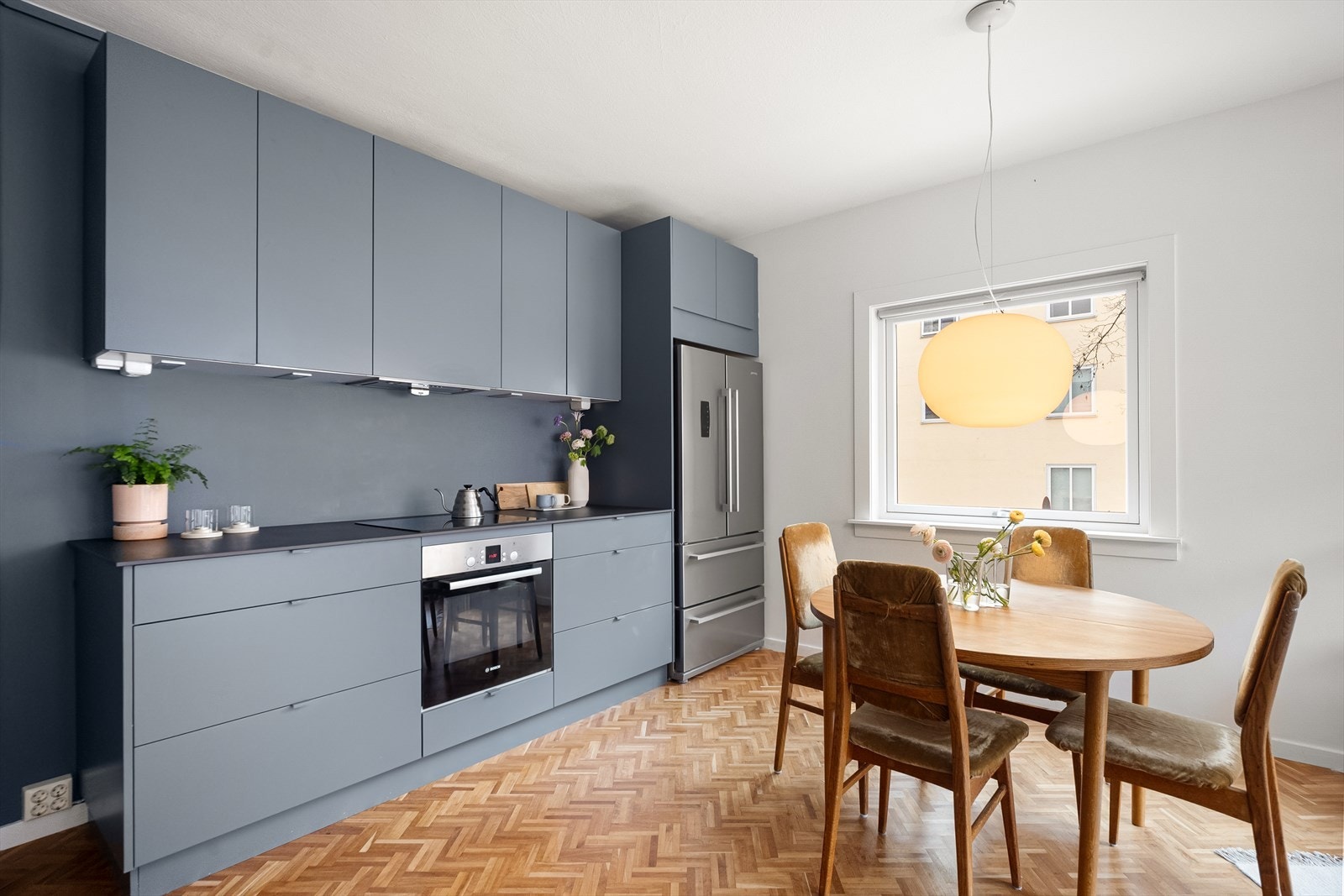 Et flott kjøkken med innredning i glatte fronter og god lagringsplass i både skuffer og skap. Benkeplaten i stein gir rikelig med arbeidsflate. Galleribilde