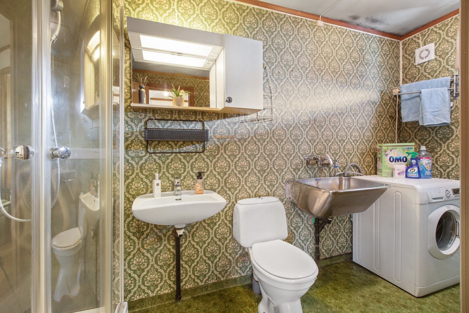 Eldre bad i utleiedelen med dusj, toalett, servant og opplegg for vaskemaskin. Galleribilde