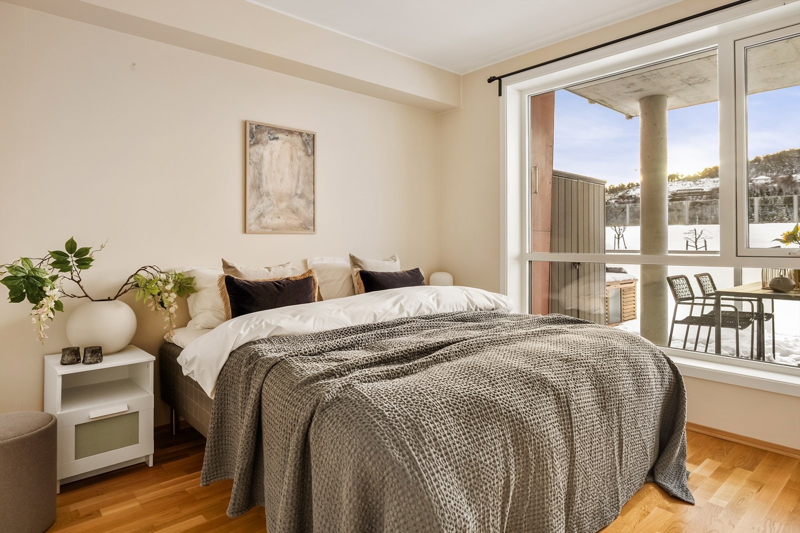 Rommet har en behagelig fargepalett med lyse vegger og varme tregulv som skaper en lun og tidløs atmosfære.
Store vindusflater slipper inn rikelig med naturlig lys og gir en luftig romfølelse. Galleribilde